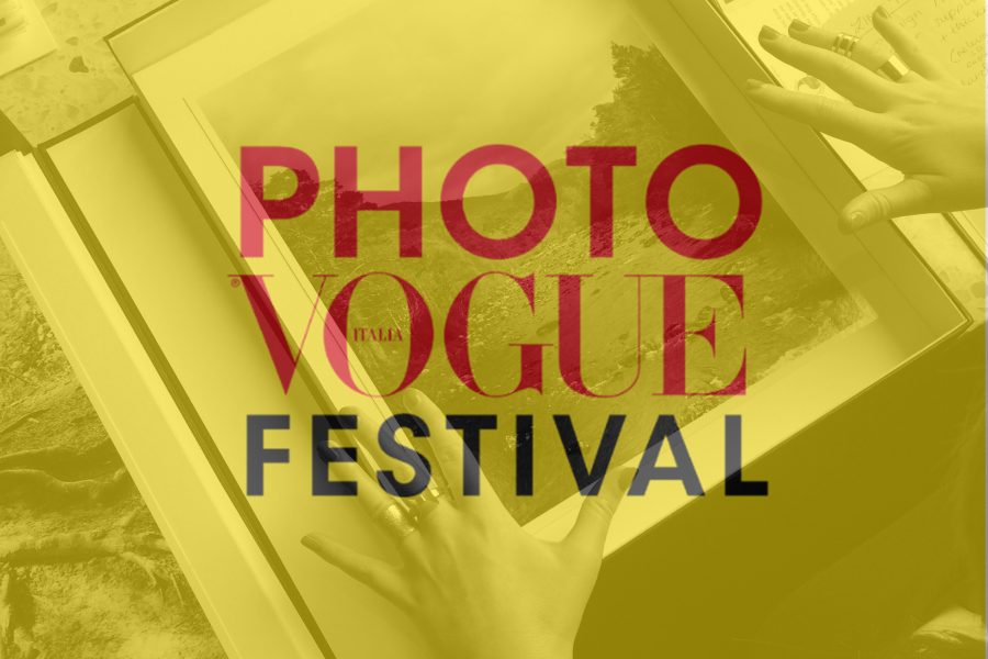 Hands with red painted nails and ornate rings either side of a box with a black and white photograph, overlaid with yellow and the text 'PHOTO VOGUE ITALIA FESTIVAL' in red and black in the centre
