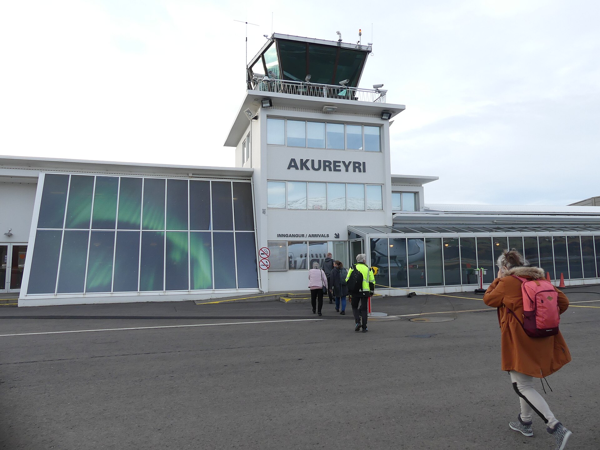 Akureyri Airport runway and apron with the town and fjord landscape nearby.