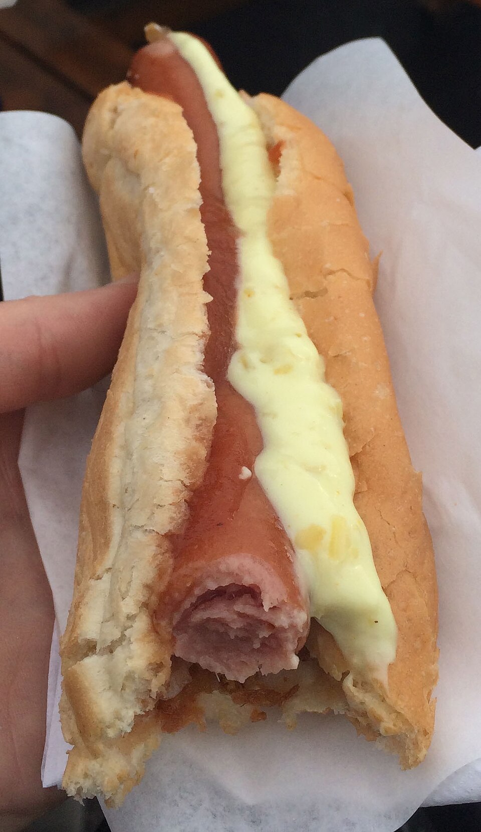 A Bæjarins Beztu Pylsur hot dog with toppings in a paper tray.