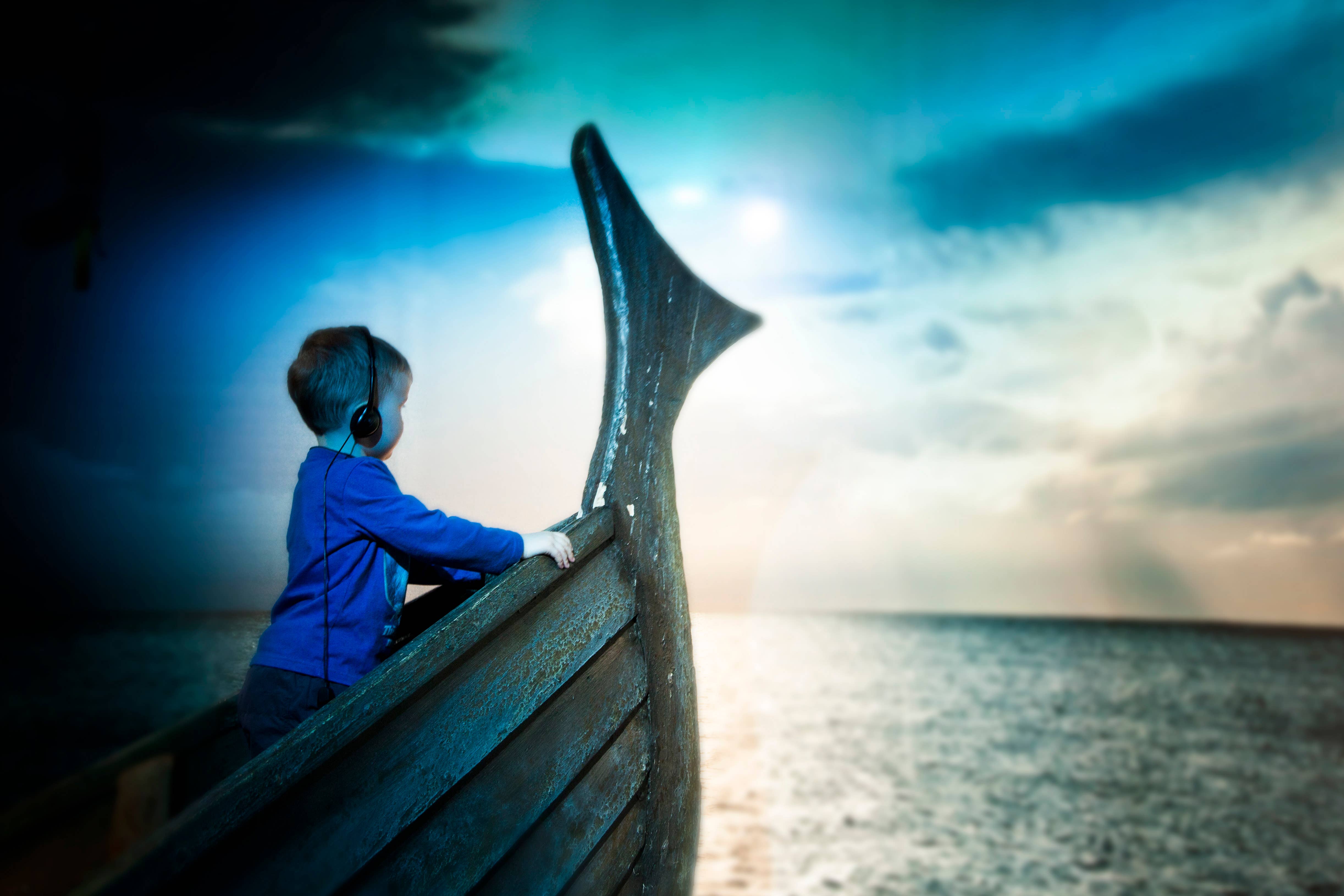 Child looking across the water from a Viking ship replica at The Settlement Center in Borgarnes.