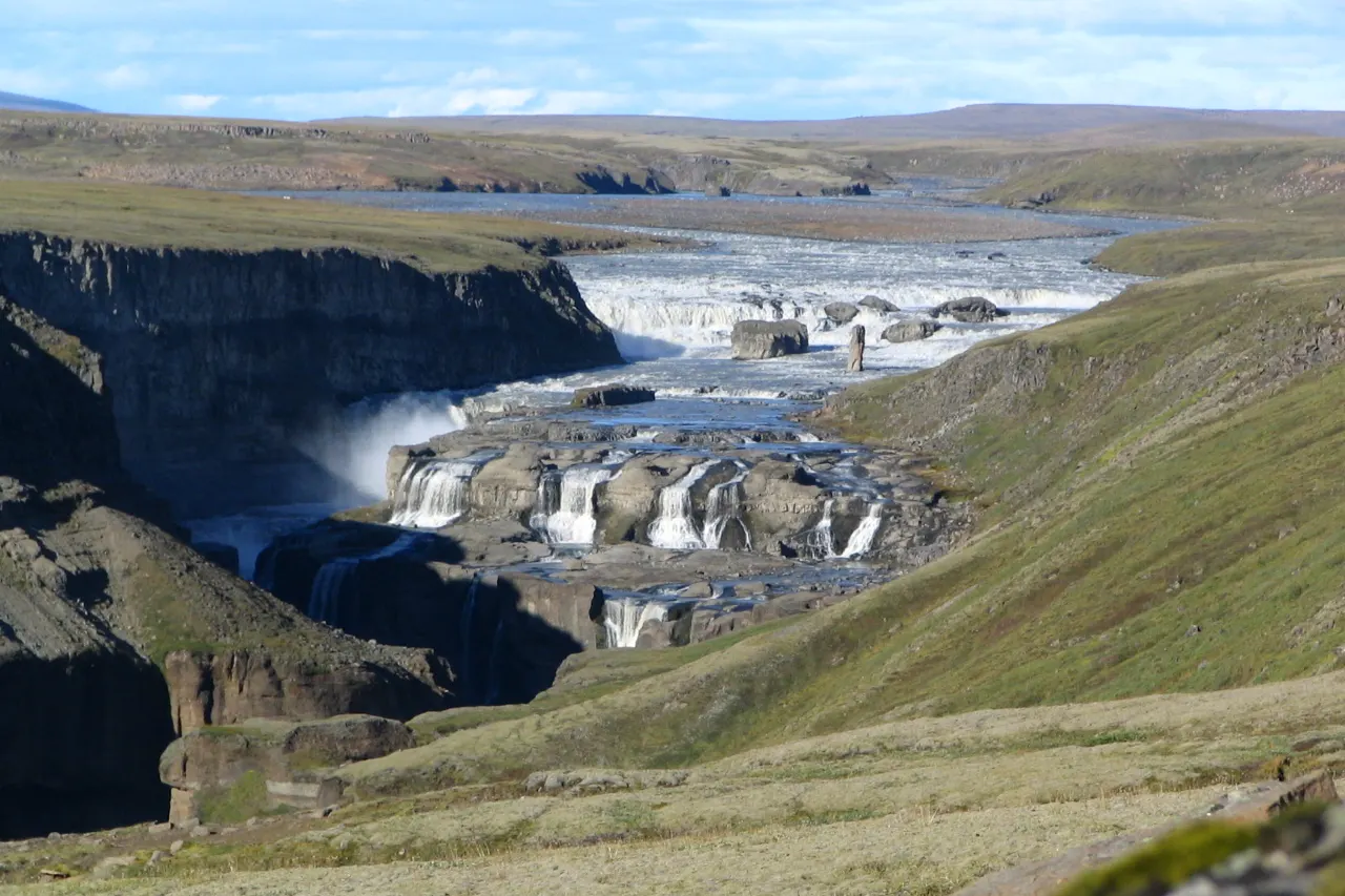 Dynkur seen from the Búðarháls side with broad Þjórsá water above the falls.