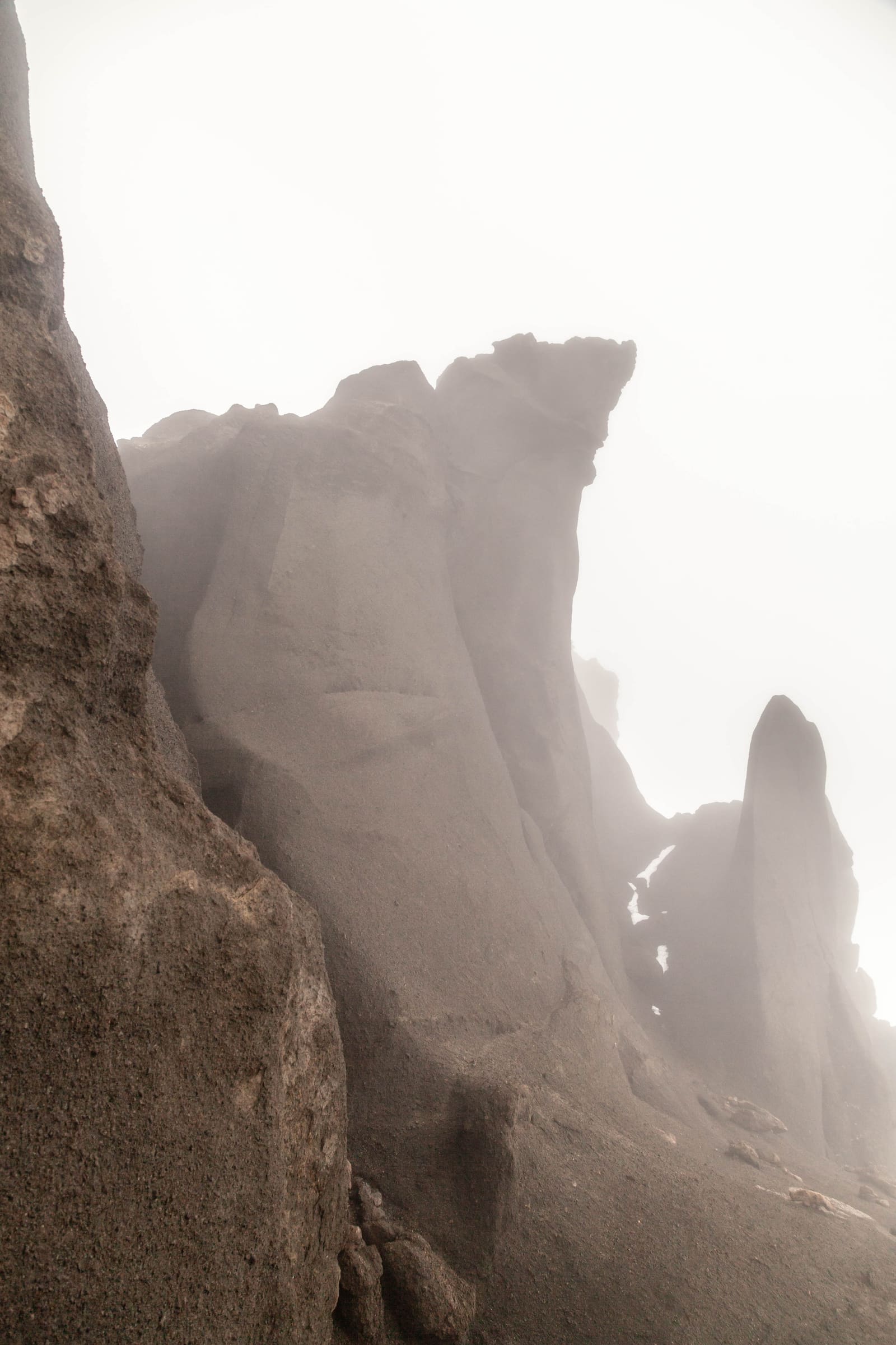 Jagged hyaloclastite formations rising through mist in Drekagil.