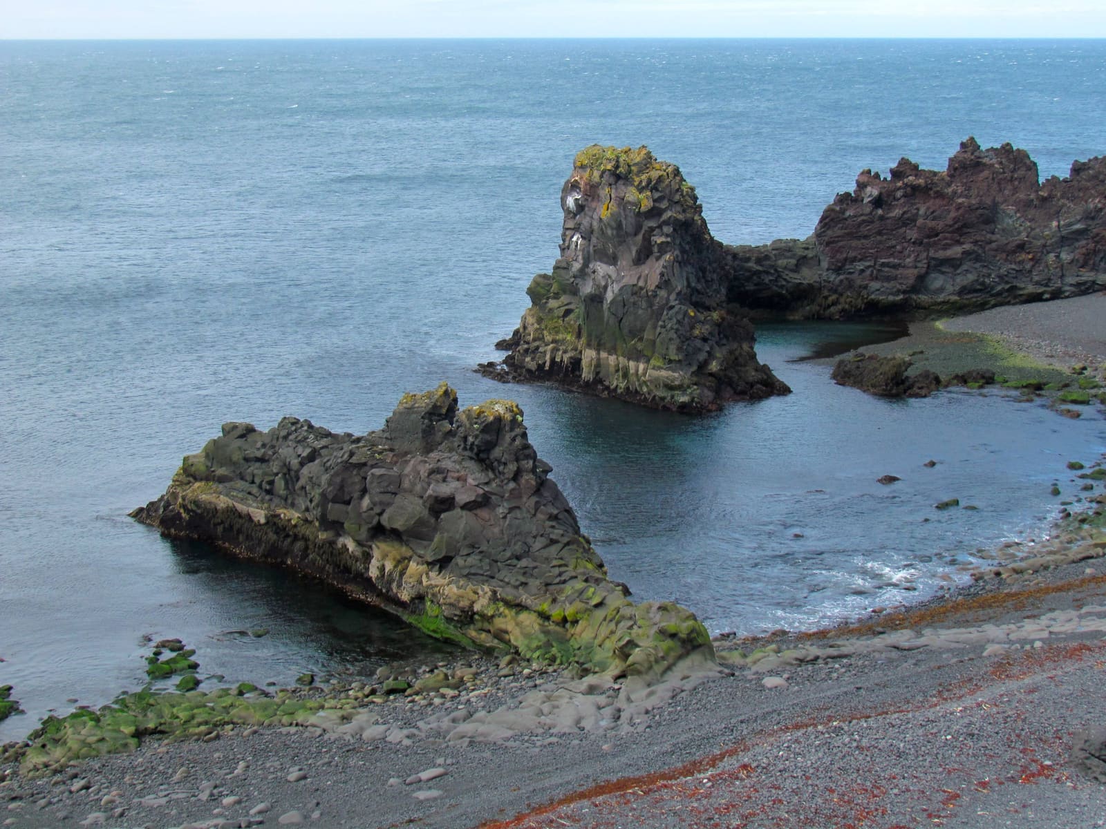 Dark rock formations and black pebbles at Dritvík Cove.