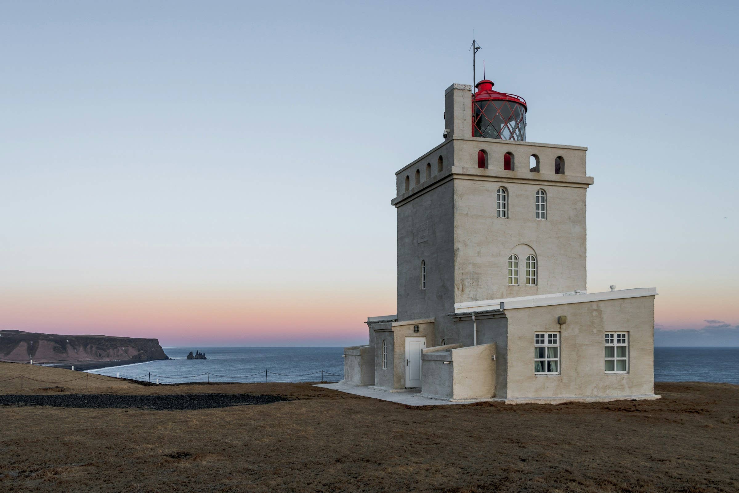 Aerial view of Dyrhólaey Lighthouse above the black-sand South Coast near Vík.