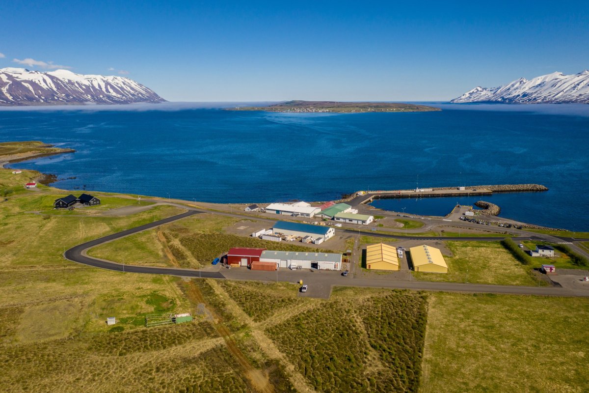 Wide view across Eyjafjörður with water, green slopes, and mountains in North Iceland.