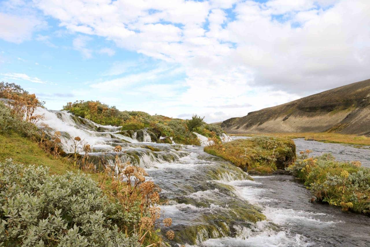 Low Fossabrekkur cascades running through green vegetation near the Ytri-Rangá river.