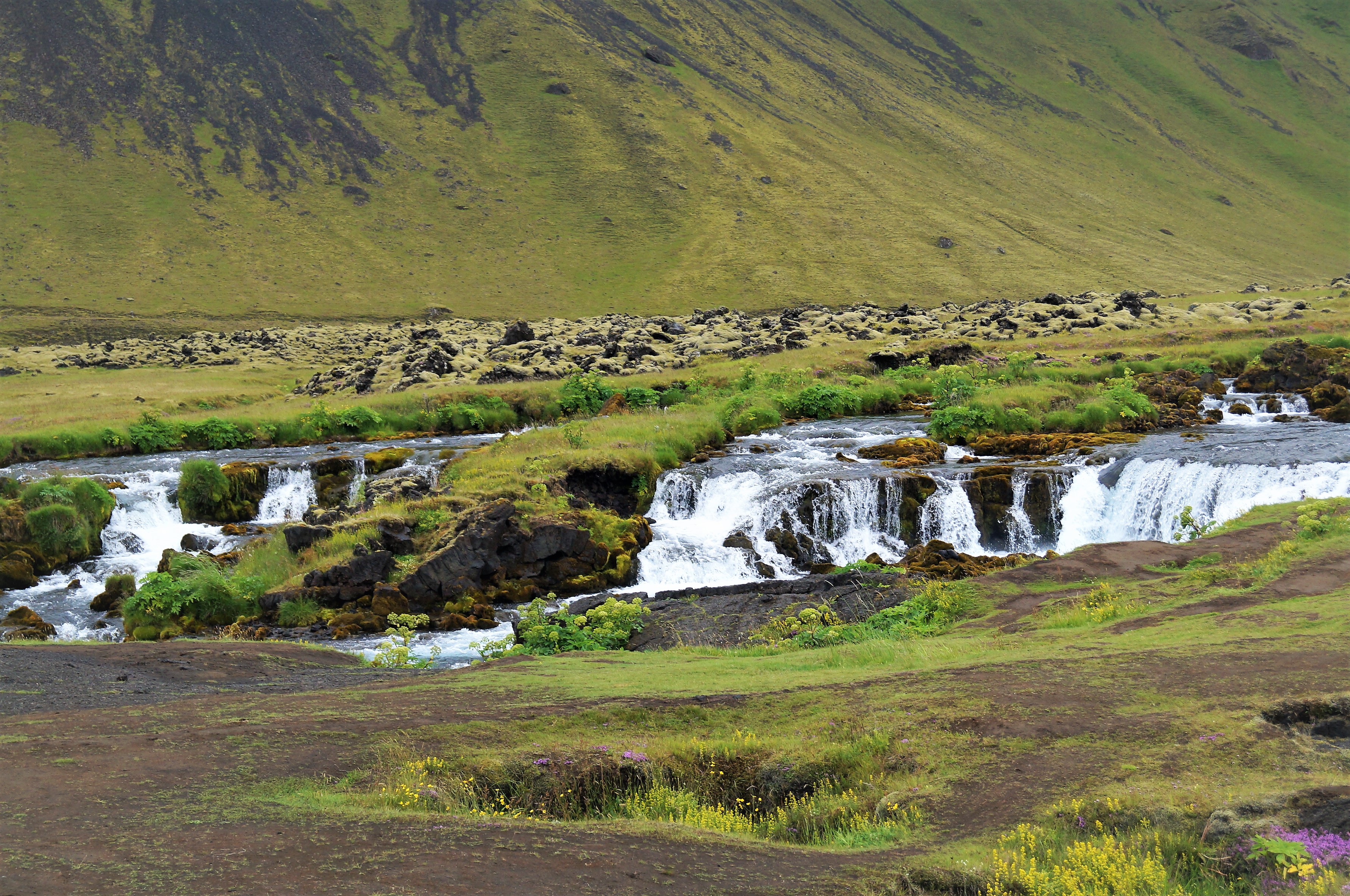 Closer view of Fossálar cascades running over dark rock in South Iceland.