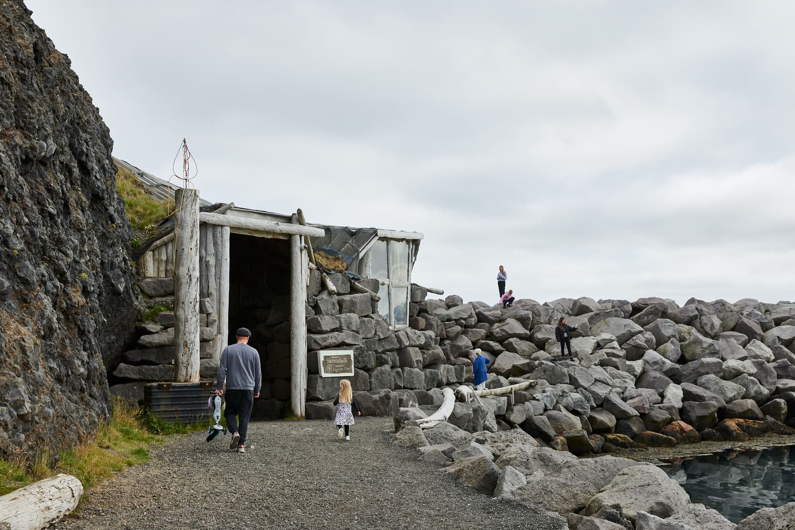 Exterior of Giantess Cave built into the rocky Keflavík marina shoreline.