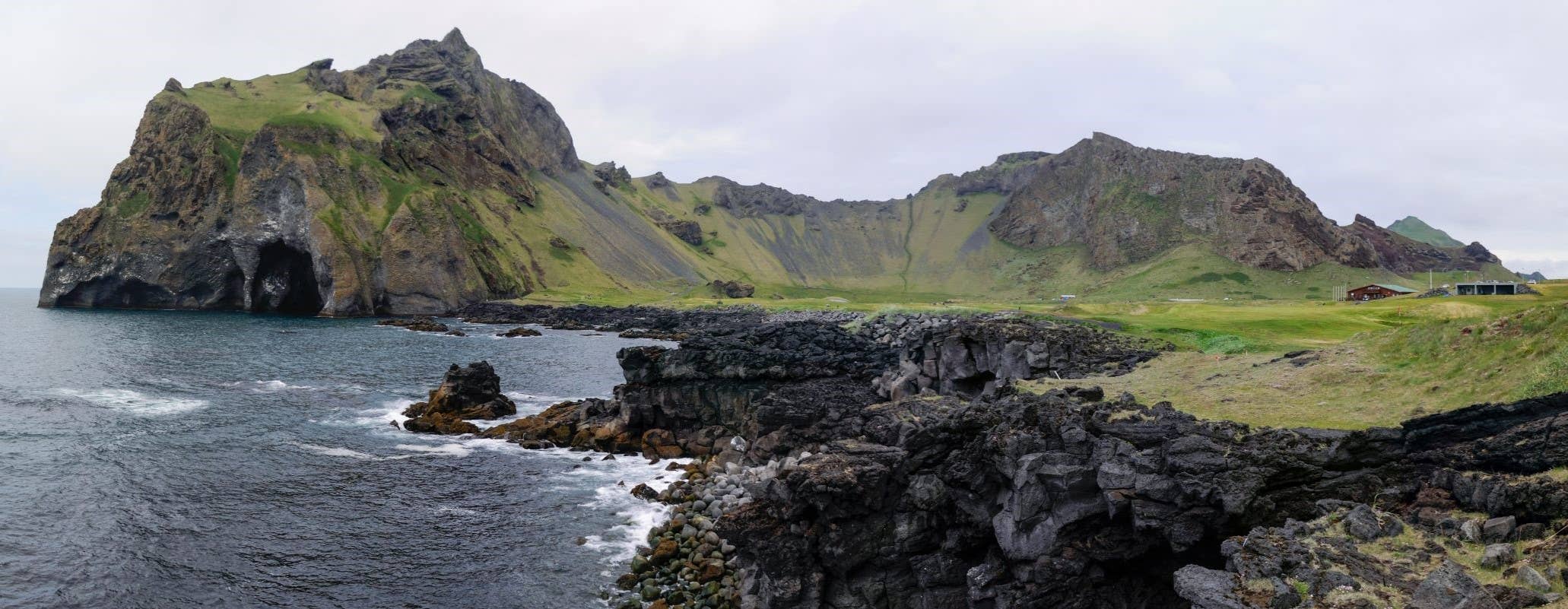 Wide view of Herjolfsdalur Valley surrounded by volcanic rock formations.