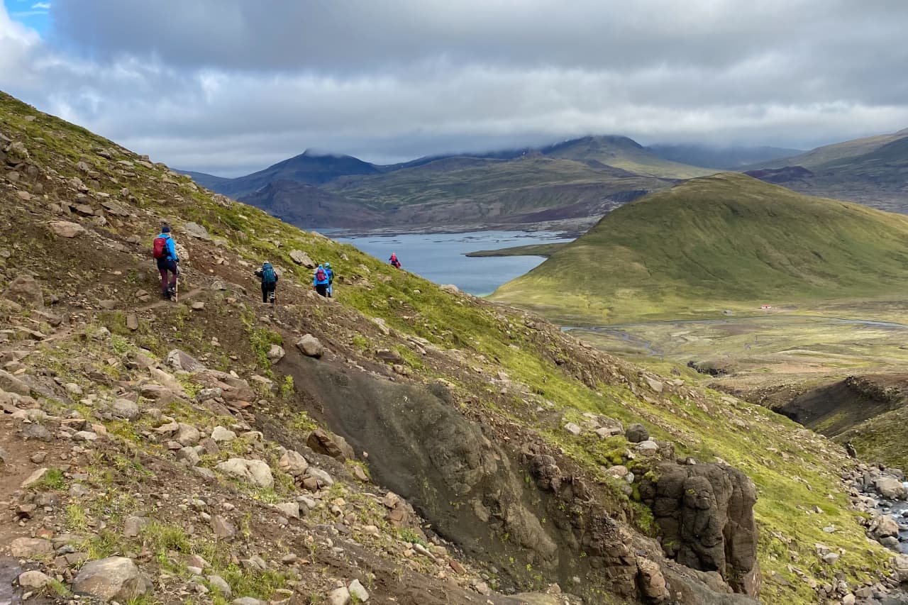 Hikers above Hlíðarvatn with West Iceland mountains and lake water below