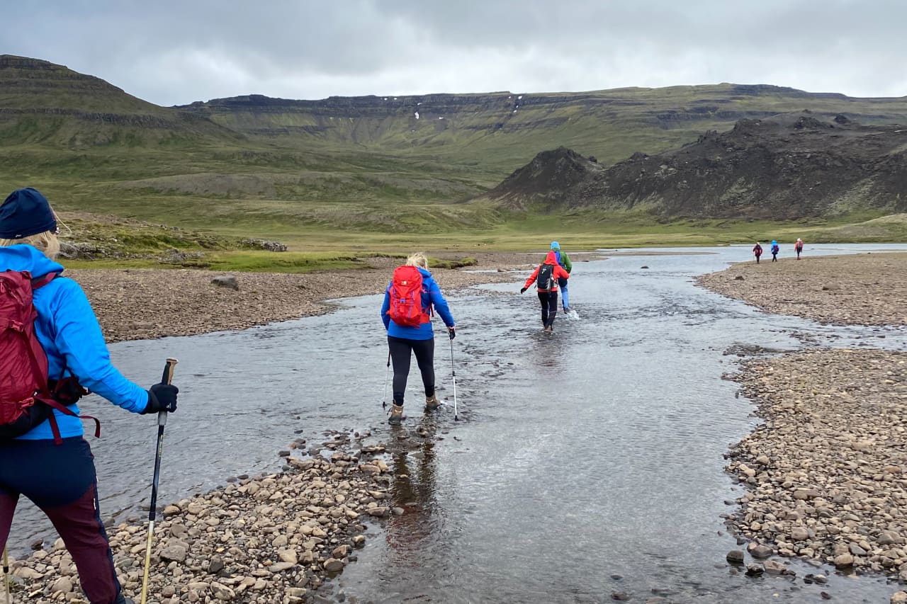 Hikers crossing shallow water on the Vatnaleið route near Hlíðarvatn