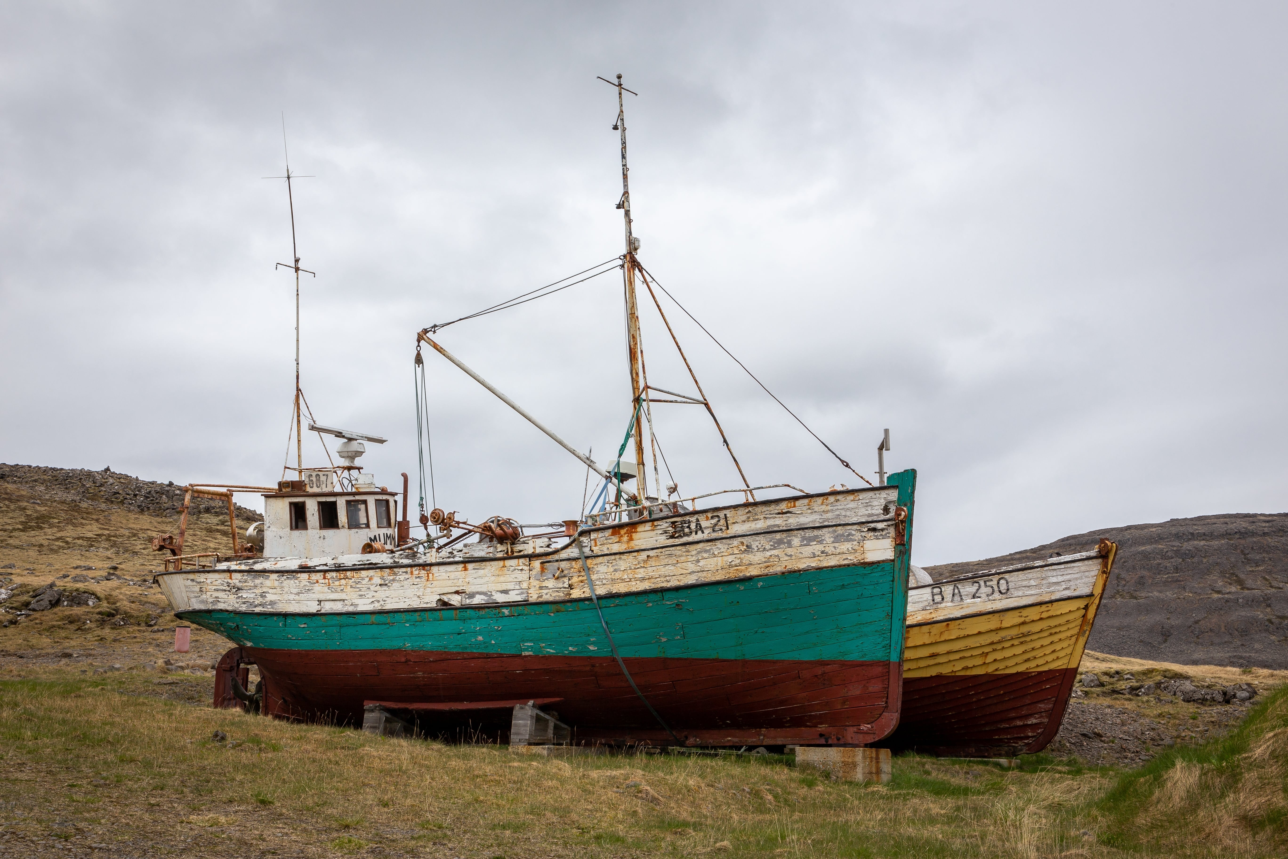 Old fishing boats displayed outside near Hnjótur Museum in the Westfjords.