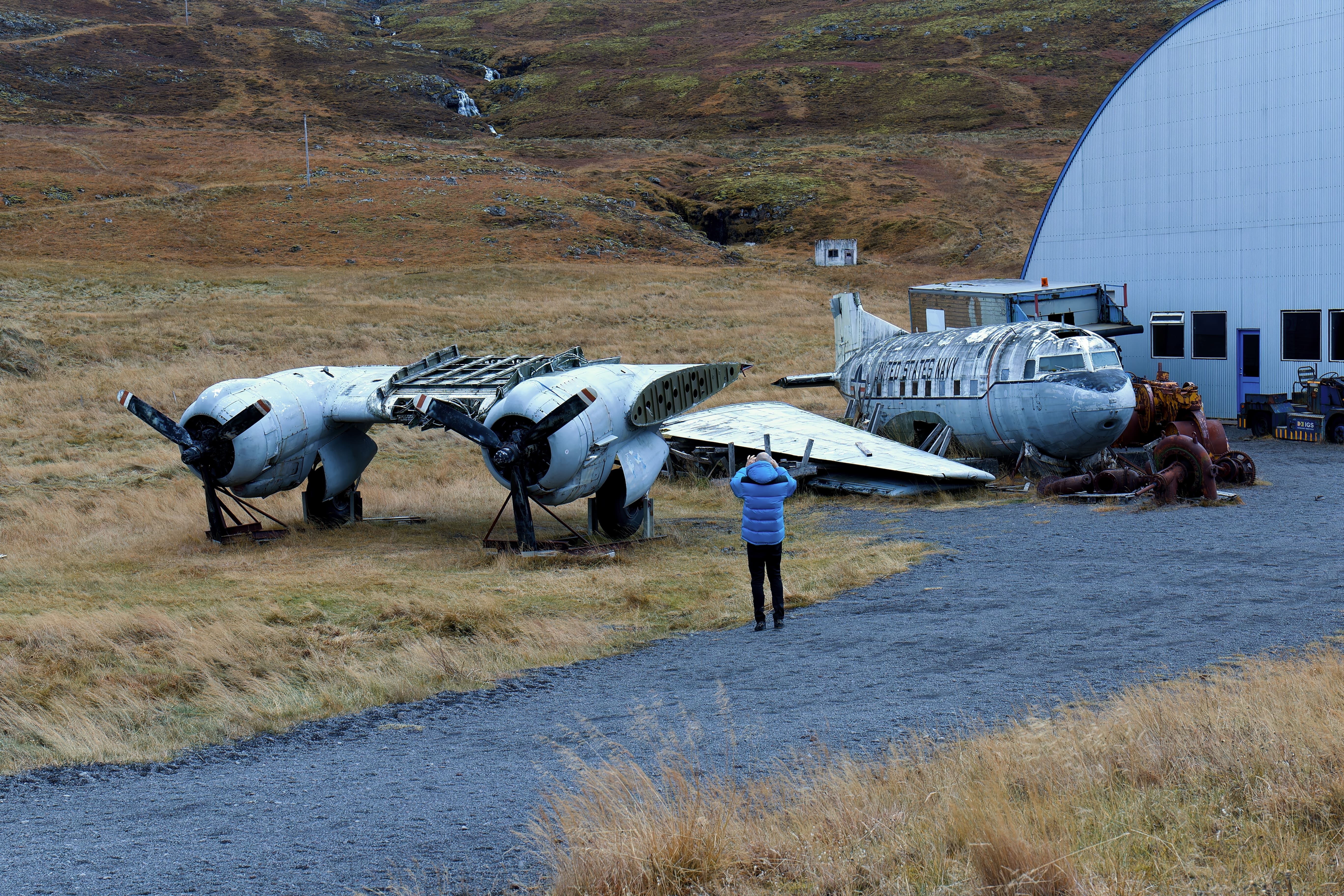 Visitor photographing a retired aircraft outside Hnjótur Museum in Iceland.