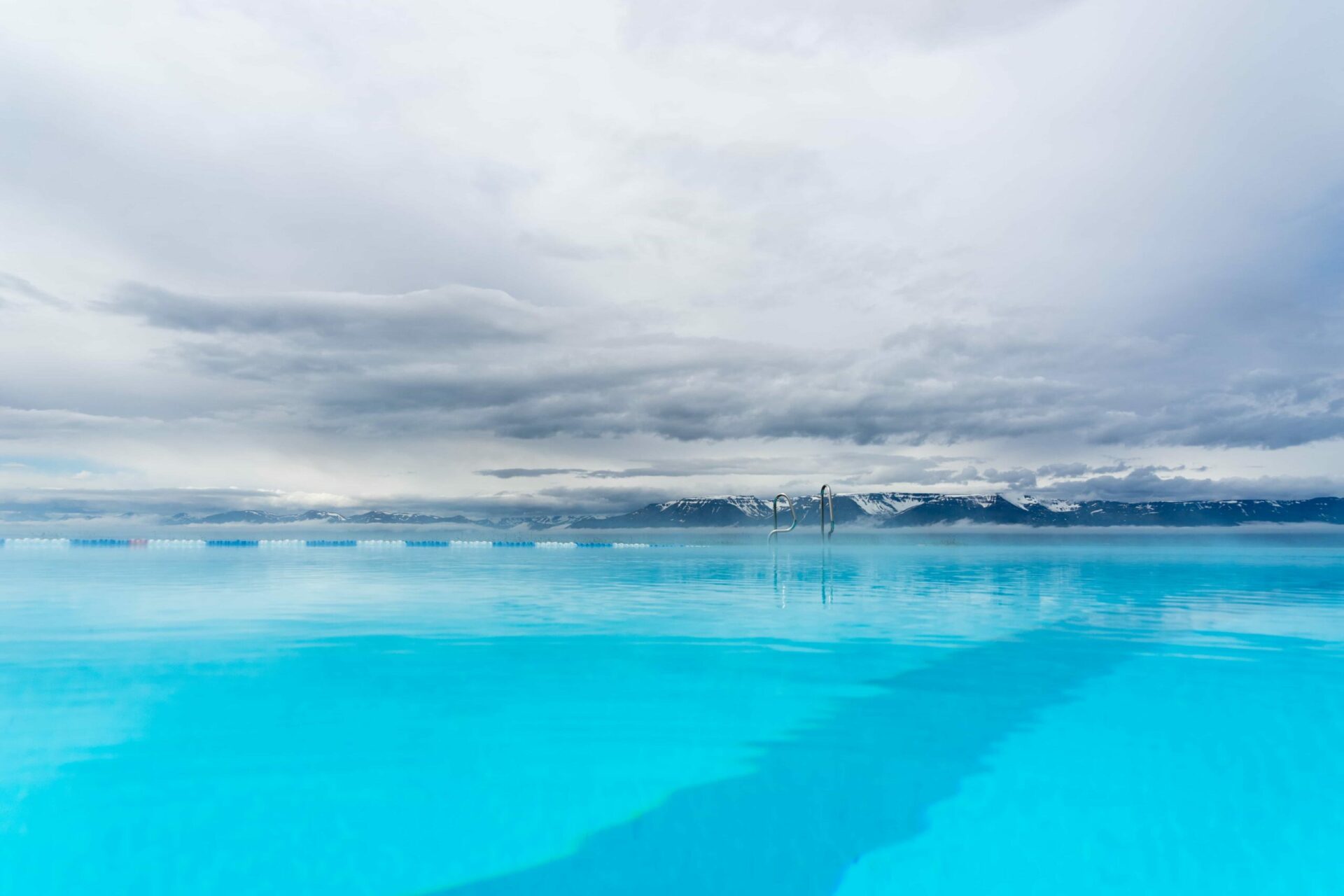 Hofsós Swimming Pool with its low pool edge, coastal setting, and fjord view.