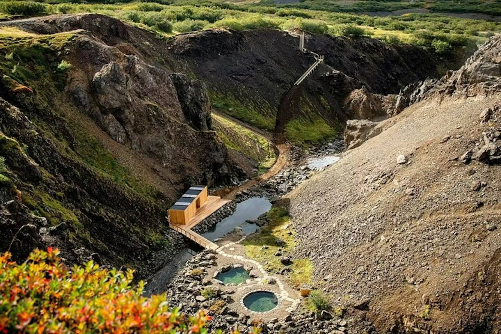 Húsafell Canyon Baths surrounded by rocky highland terrain and low canyon slopes.