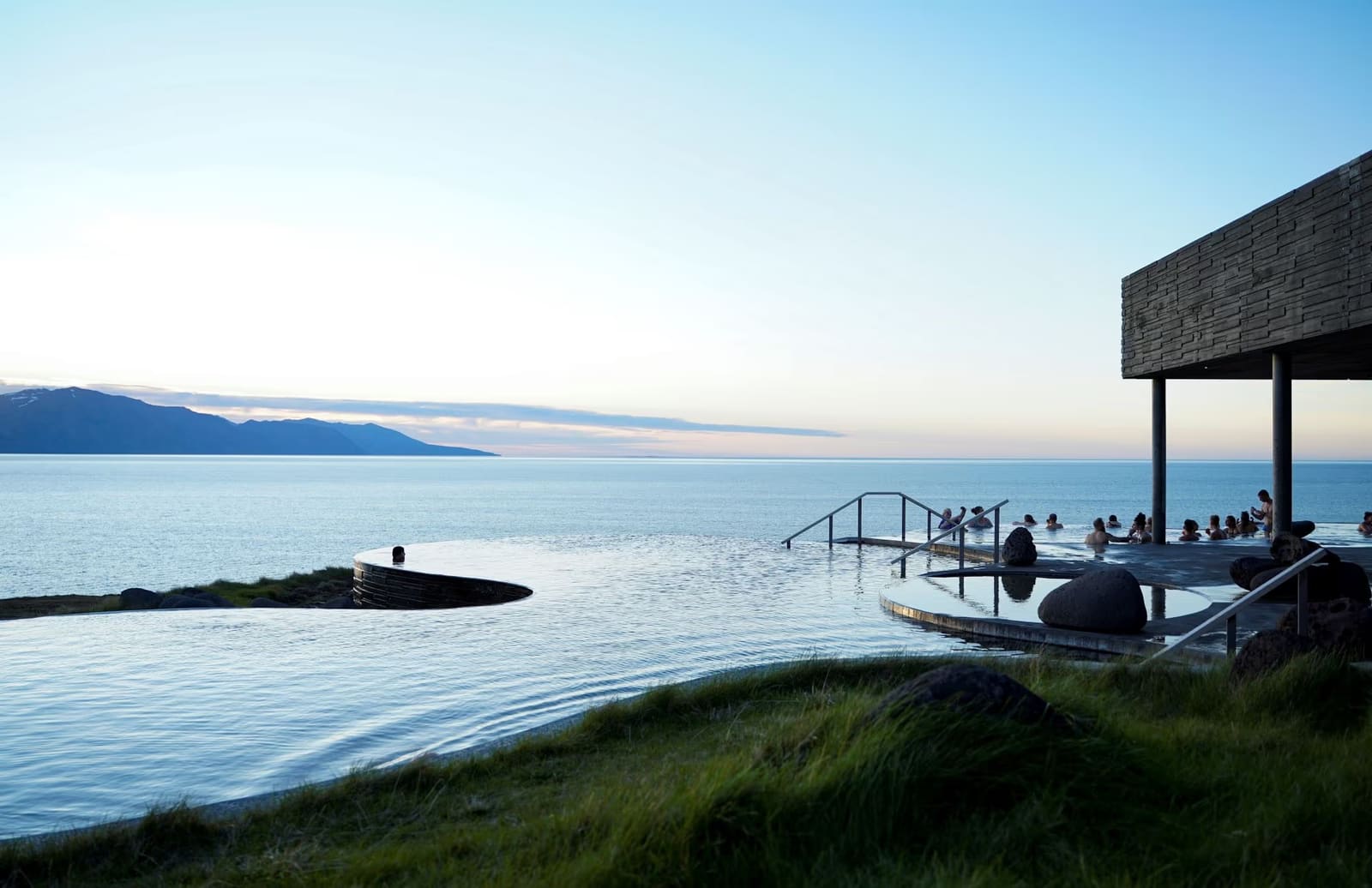 GeoSea pools on the Húsavíkurhöfði cliff edge looking across Skjálfandi Bay.