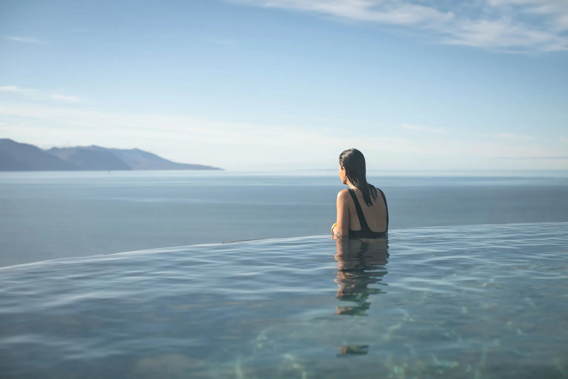 GeoSea pool edge on Húsavíkurhöfði looking across Skjálfandi Bay toward the mountains.