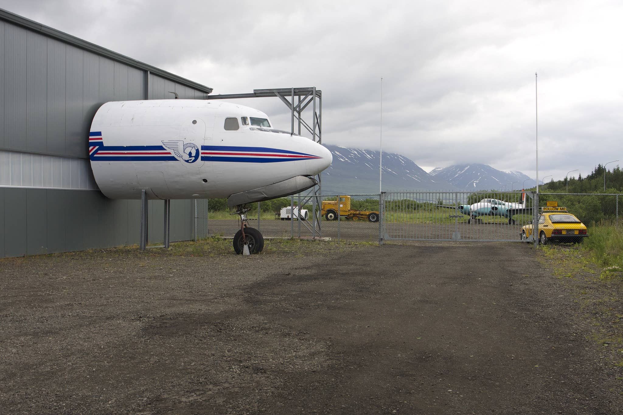 Exterior of the Icelandic Aviation Museum hangar in Akureyri with an aircraft nose projecting from the wall.