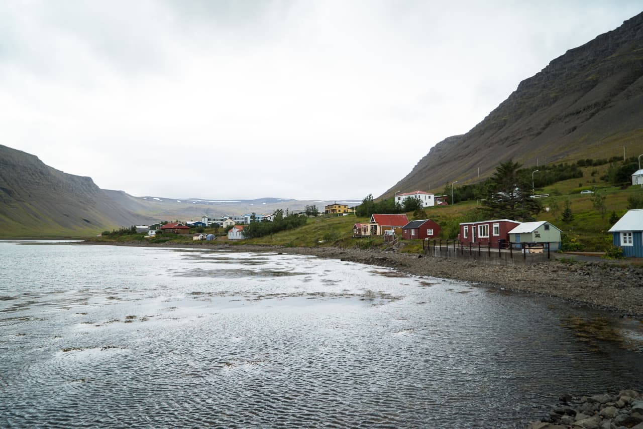 Bíldudalur village houses along Arnarfjörður below steep Westfjords mountains.