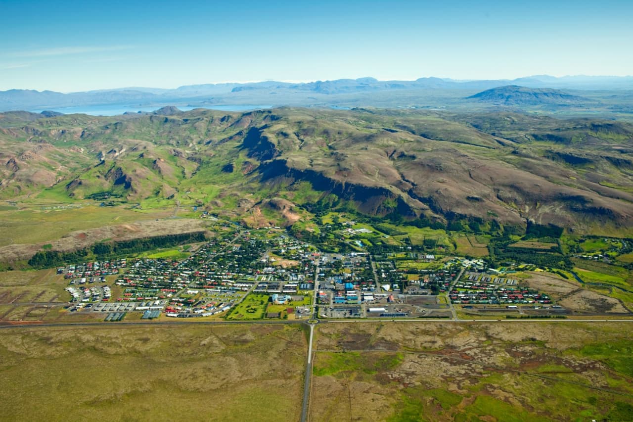 Hveragerði spread across a green valley below hills near Ingólfsfjall.
