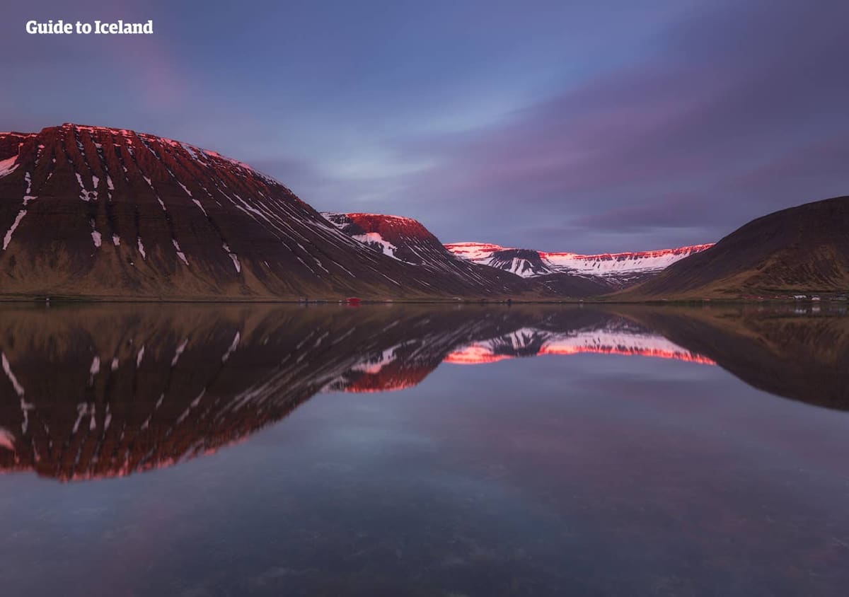 Snowy mountains reflected in still Skutulsfjörður water around Ísafjörður in the Westfjords.