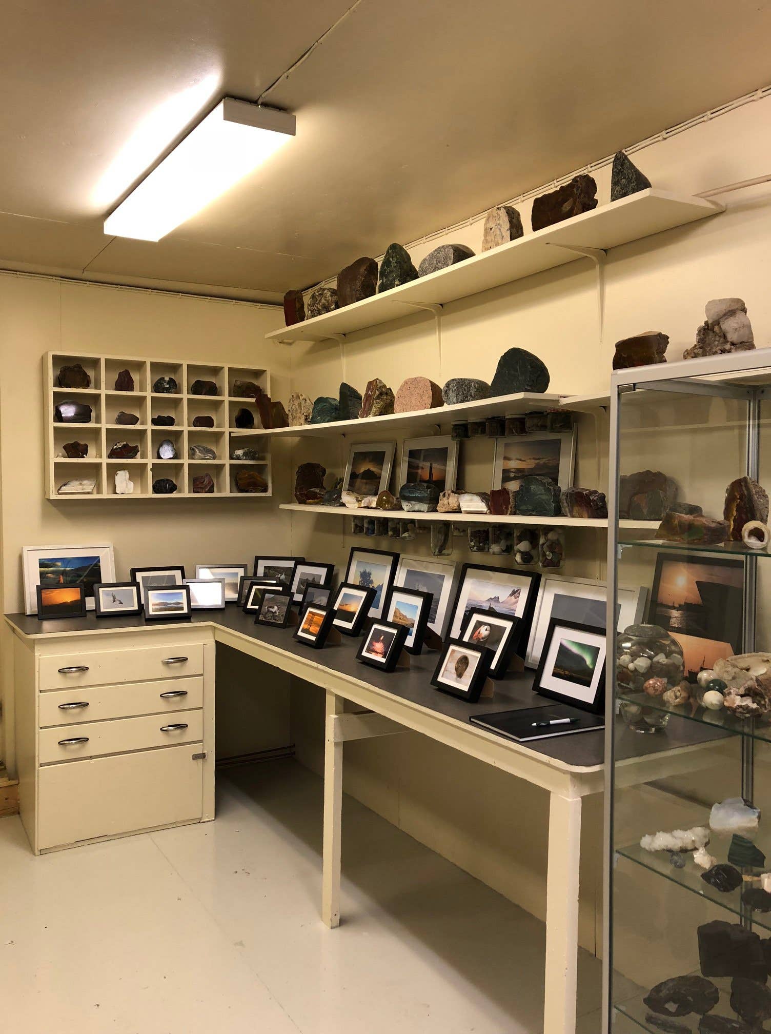 Interior display of stones and photographs inside Kiddi's Workshop in Hofn.