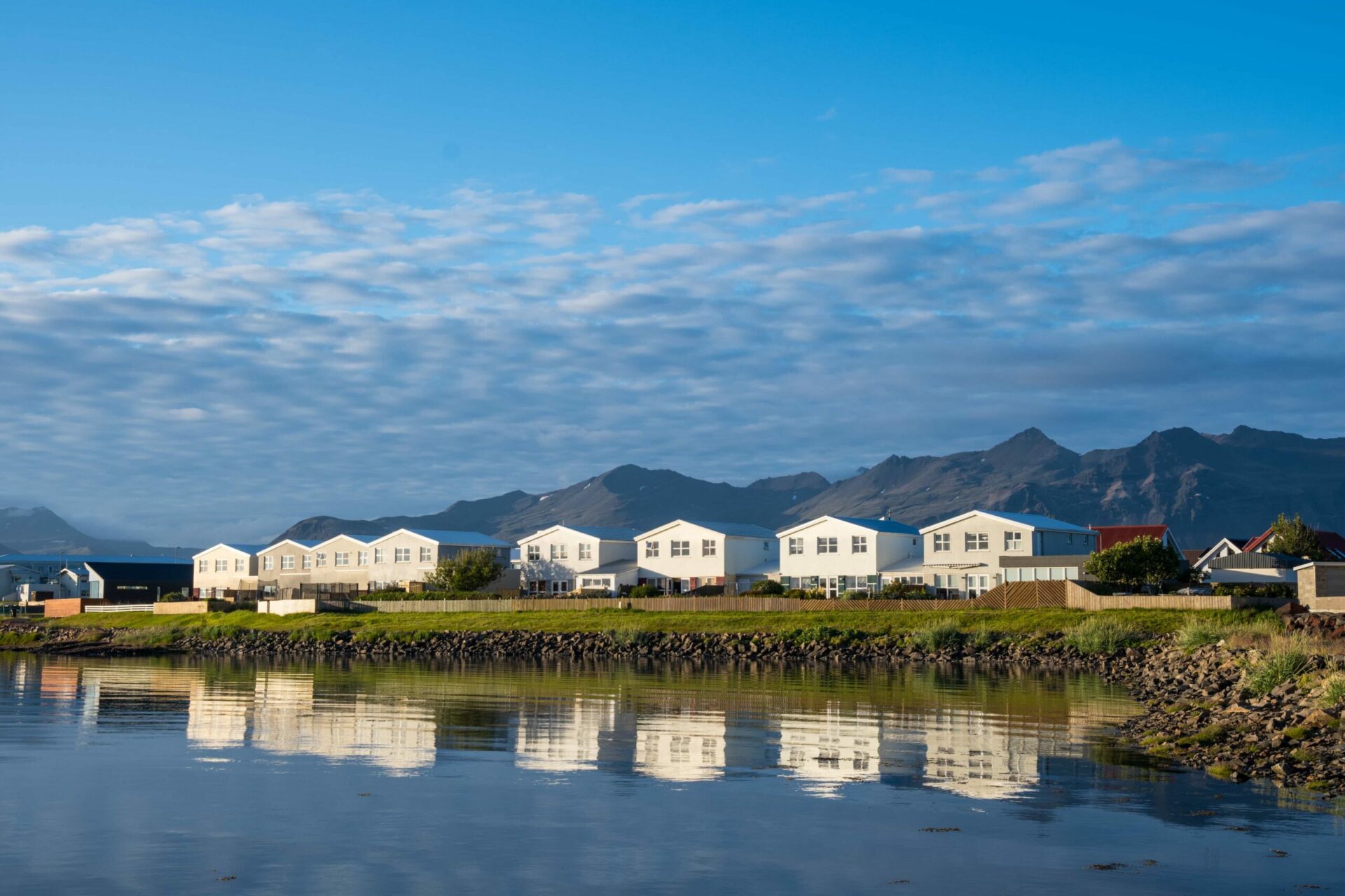 Hofn waterfront buildings with mountains rising behind the town.