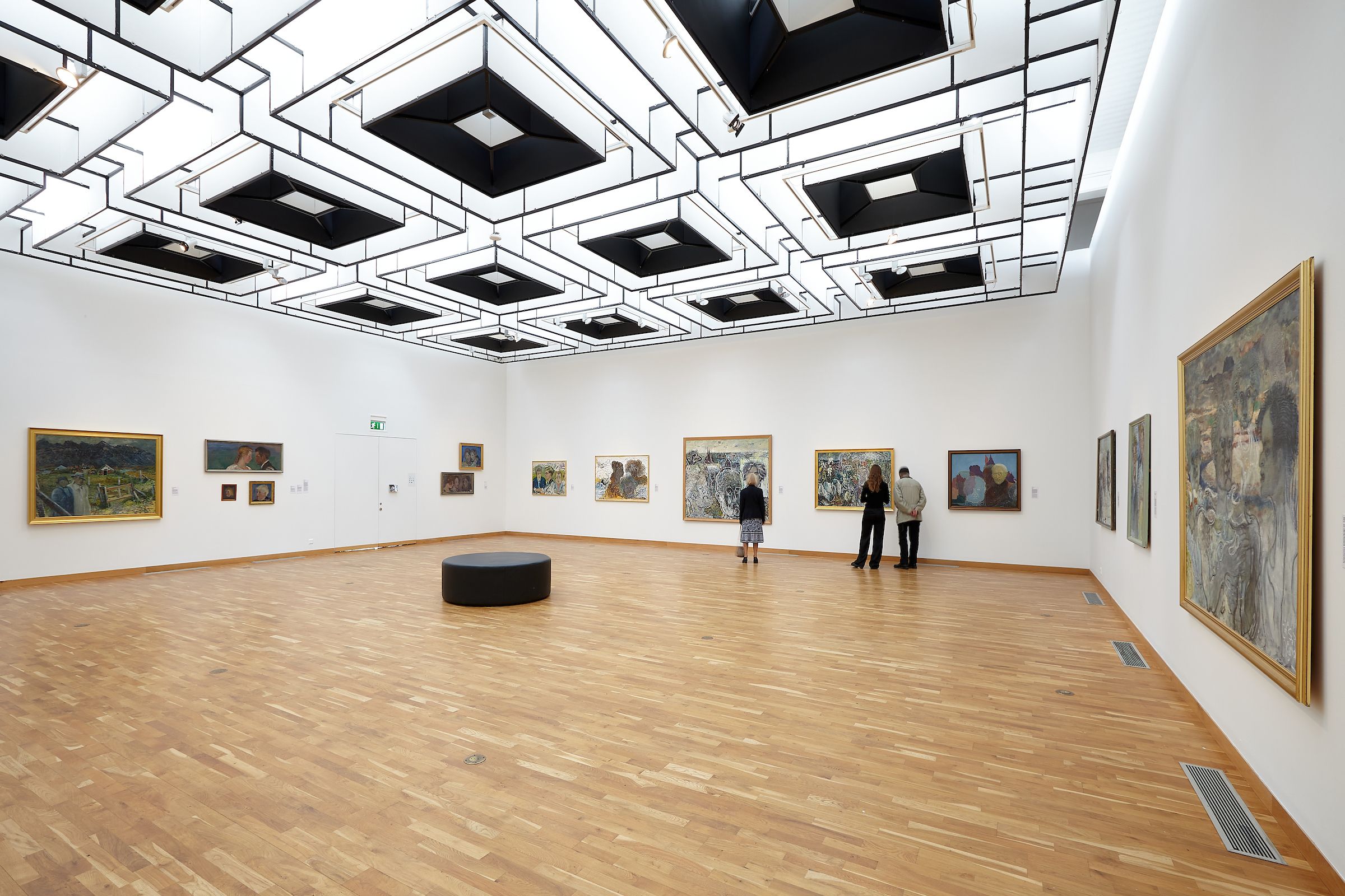 Visitors viewing paintings in a bright gallery at Kjarvalsstaðir