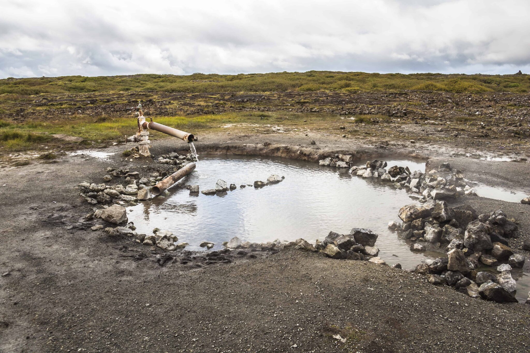 A larger water pool and pipe-fed flow at the Landbrotalaug hot spring site.