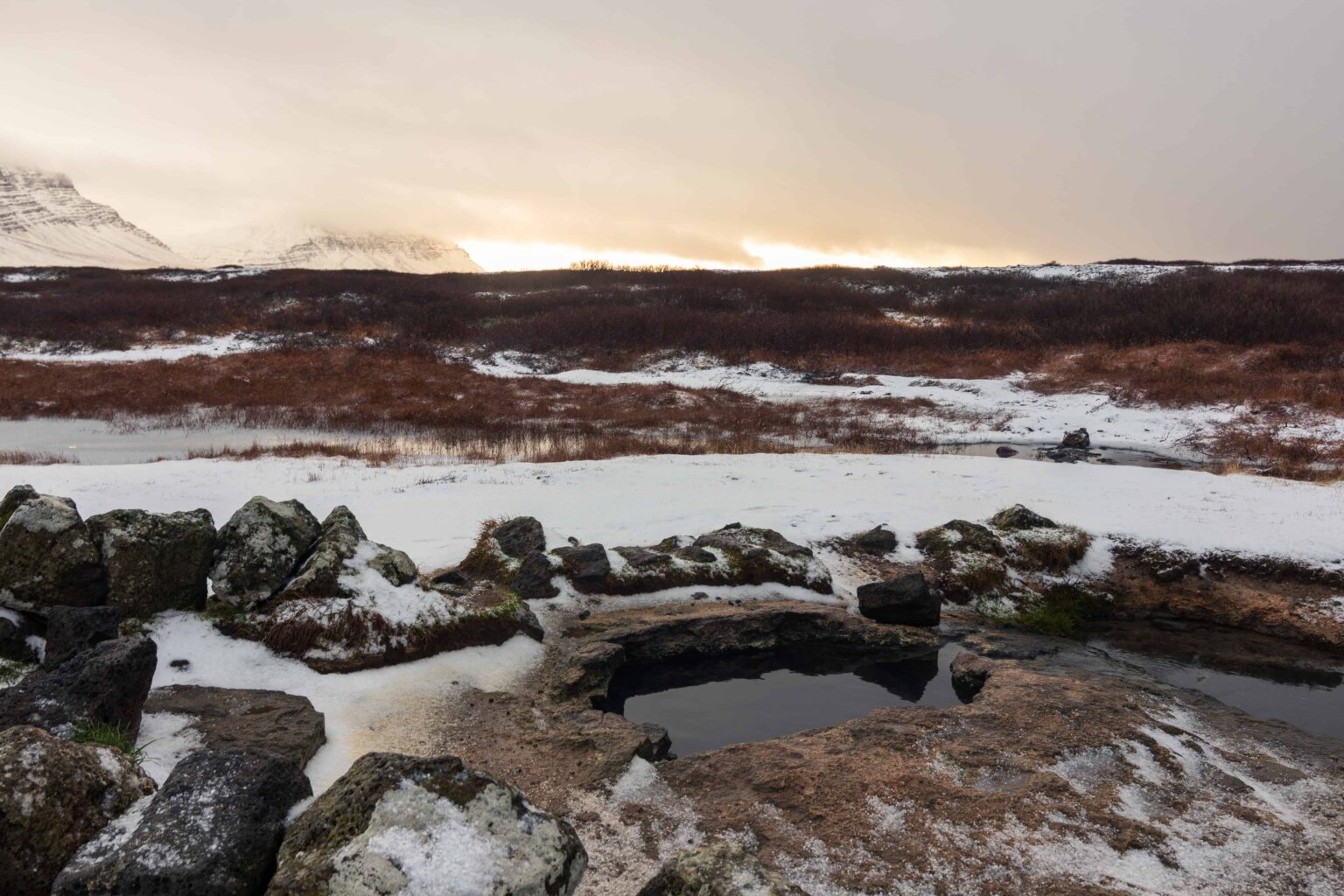 Landbrotalaug hot spring in a snowy open landscape on the Snæfellsnes Peninsula.