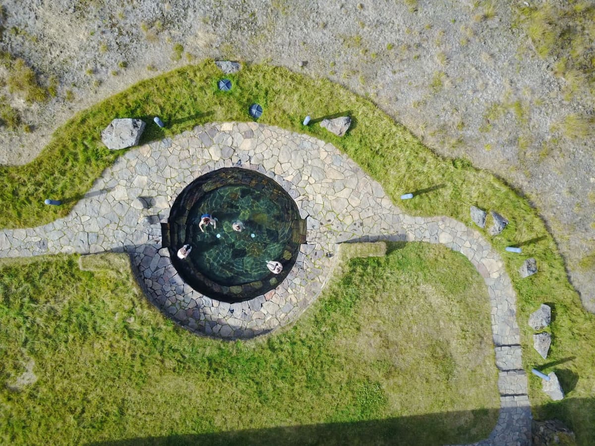 Aerial view of the circular Laugarfell hot spring pool and stone paths in East Iceland.