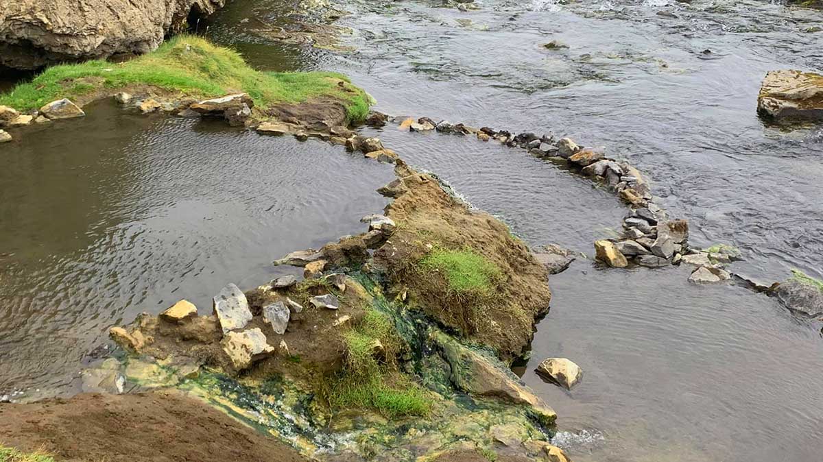 Detail of the Laugavallalaug natural hot spring and rocky warm-water channel.