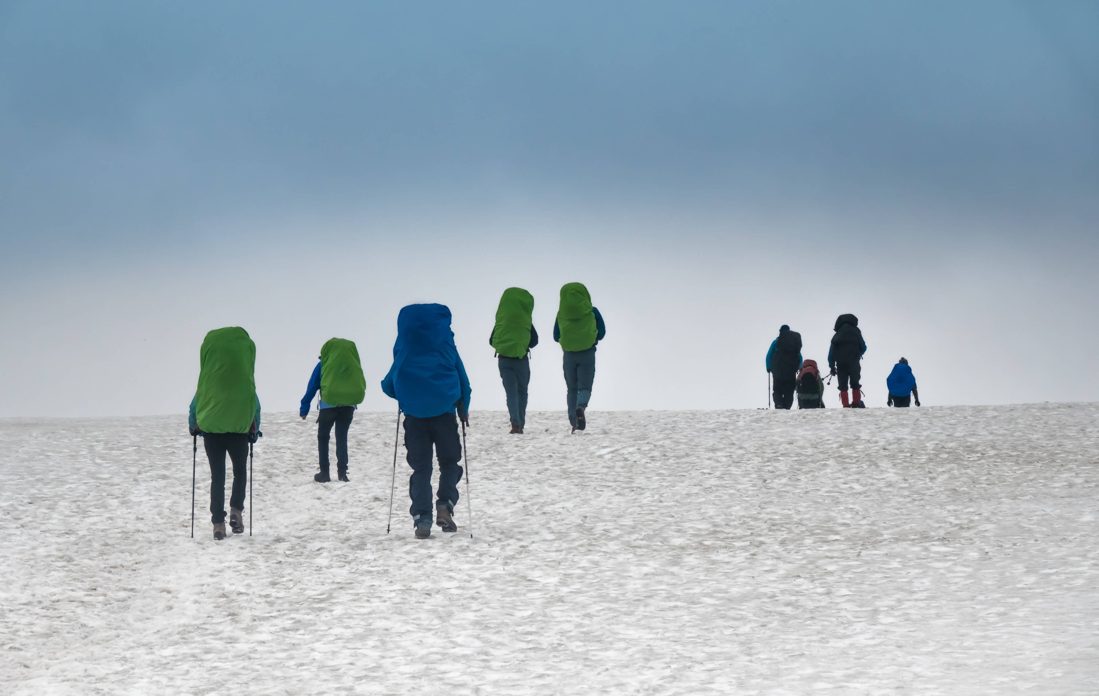 Hikers walking through open highland terrain on the Laugavegur Hiking Trail.
