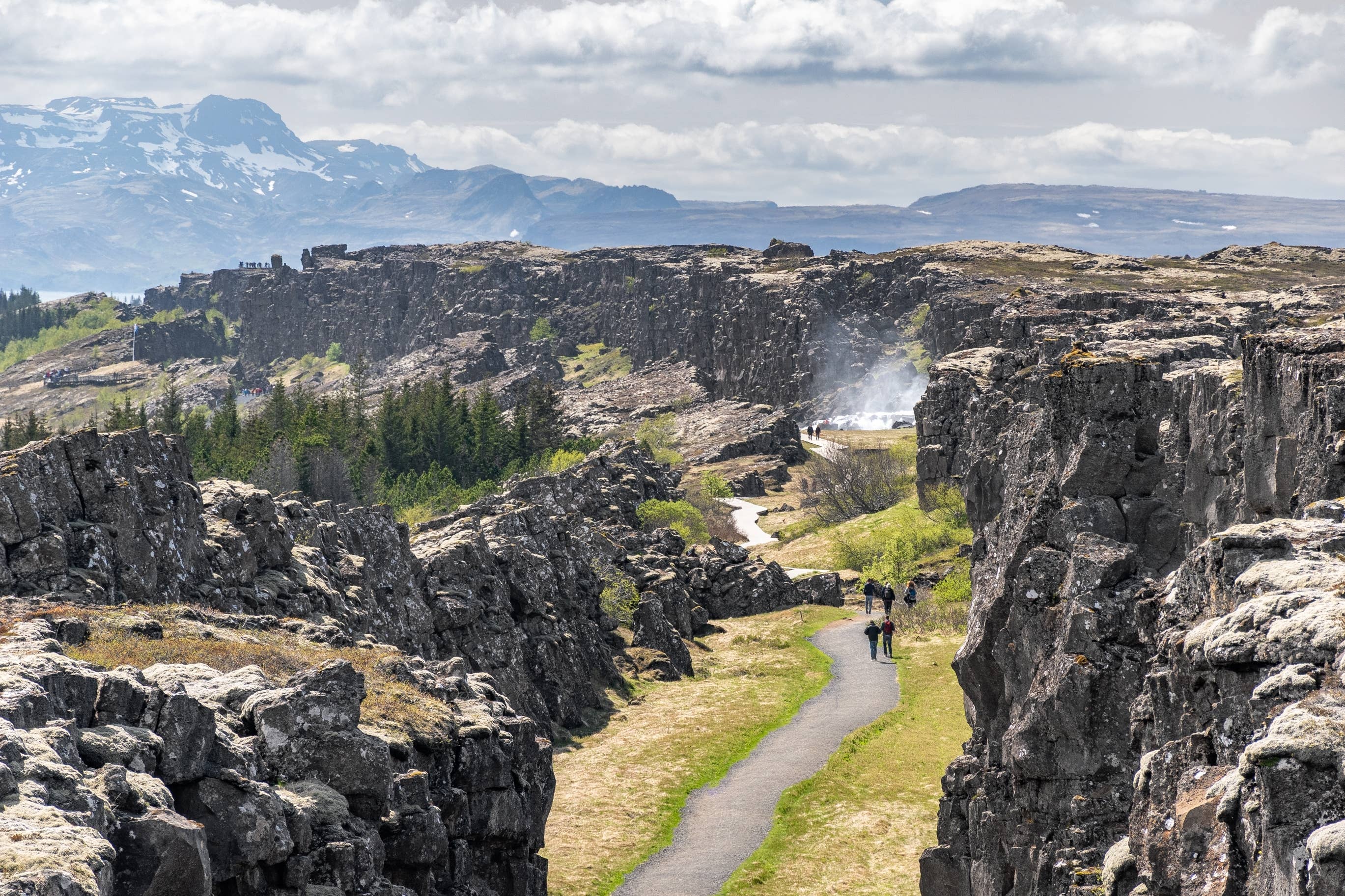 Visitors walking along Almannagjá gorge in Þingvellir National Park.