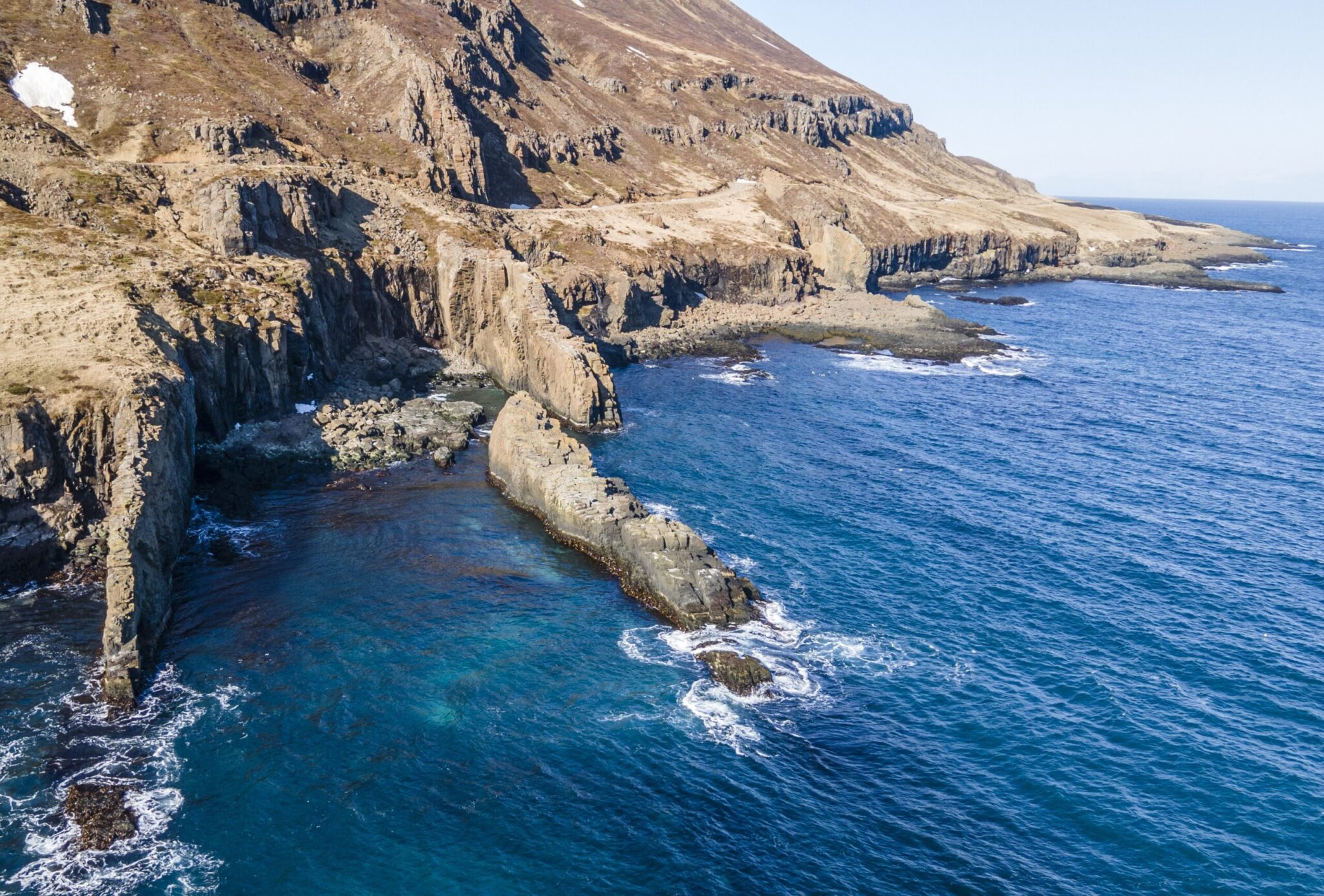 Remote shoreline and steep slopes at Smjörvogur along Mjóifjörður.