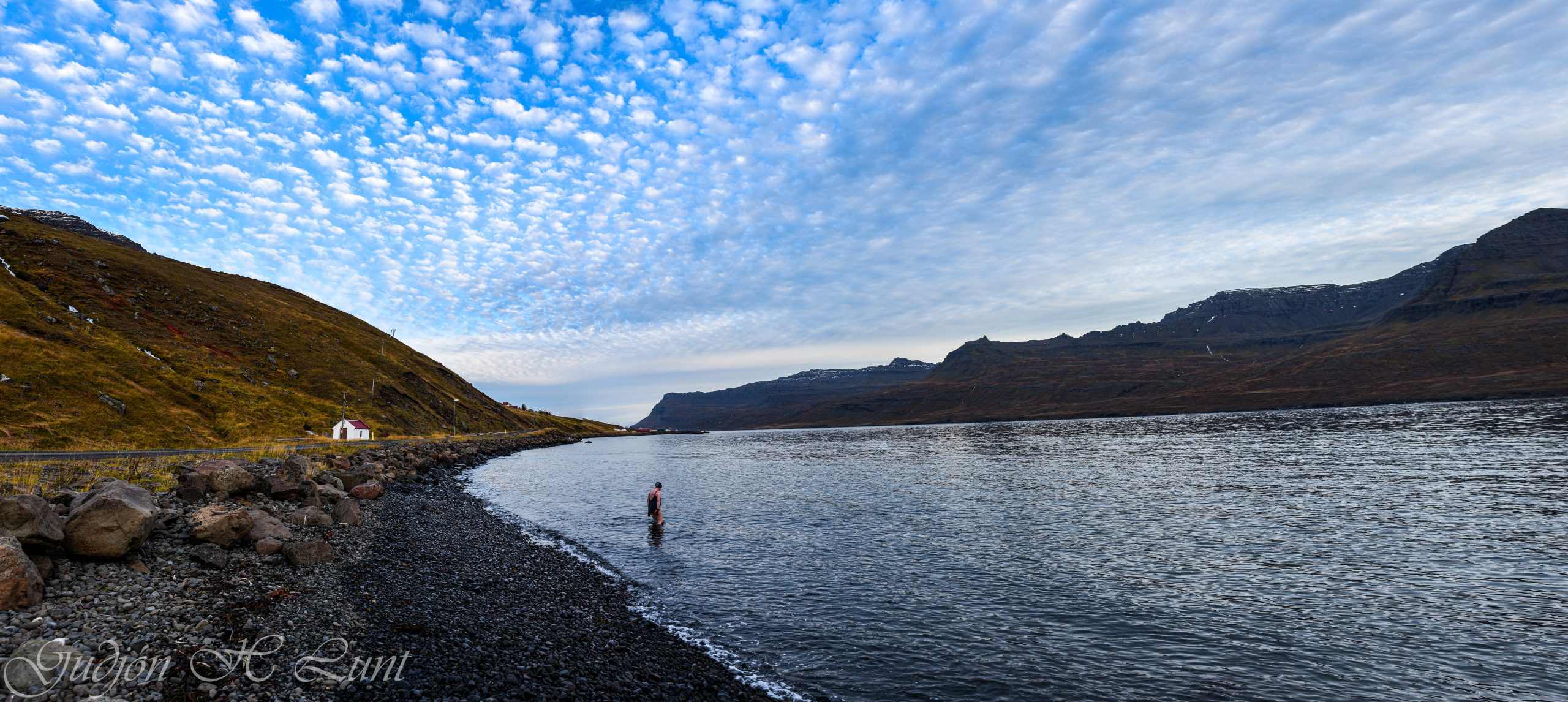 Wide panorama of Mjóifjörður with water, mountains, and the remote fjord setting.