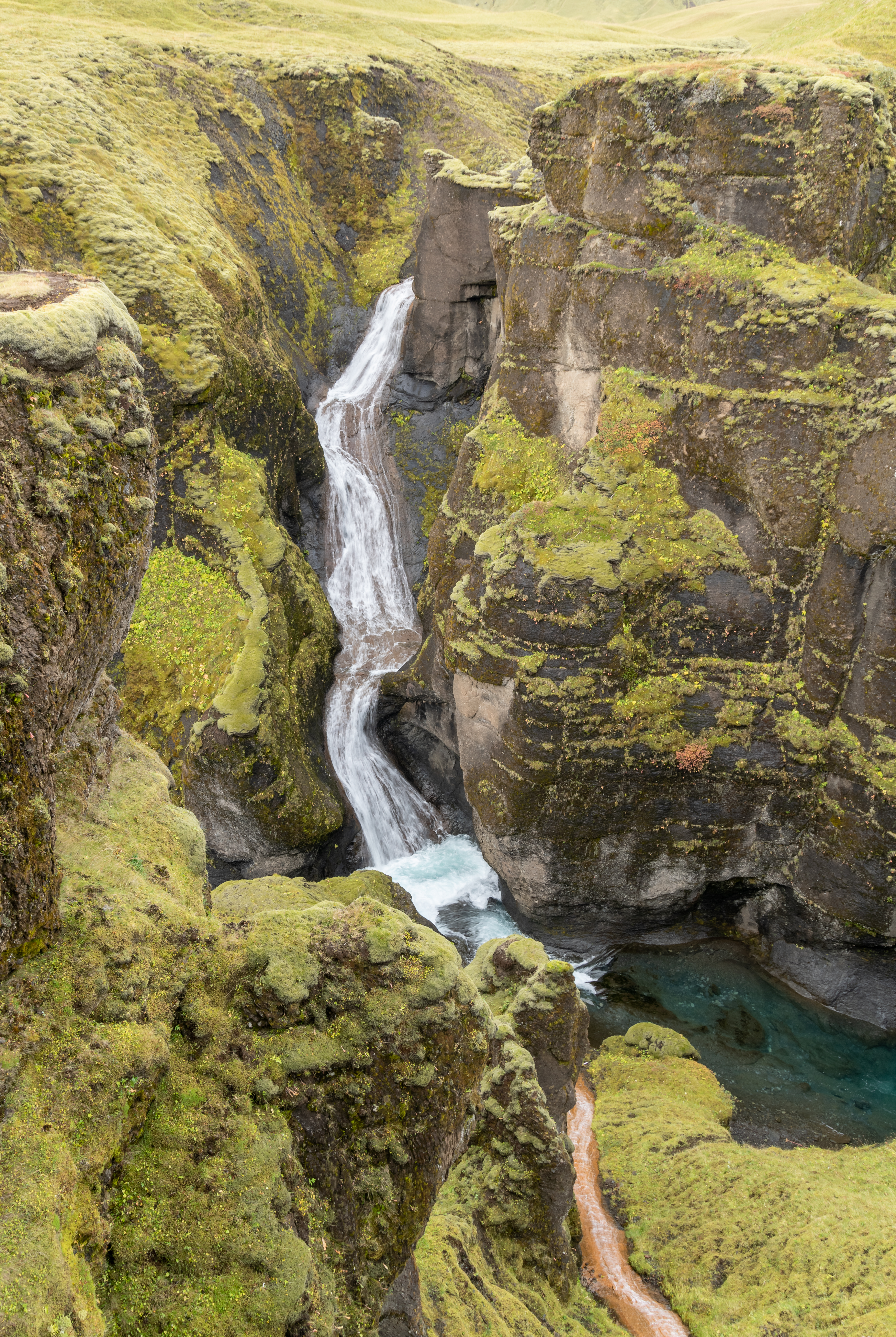 Mögáfoss waterfall descending a mossy wall inside Fjaðrárgljúfur canyon.