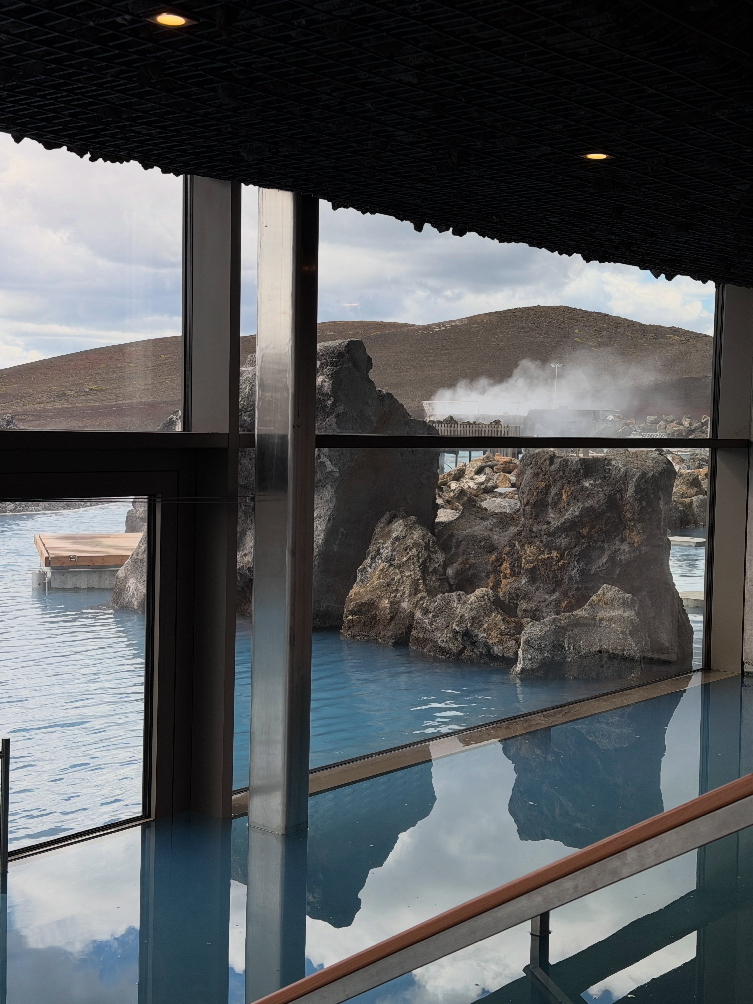 Earth Lagoon Mývatn water and steaming volcanic ground seen through the new building.