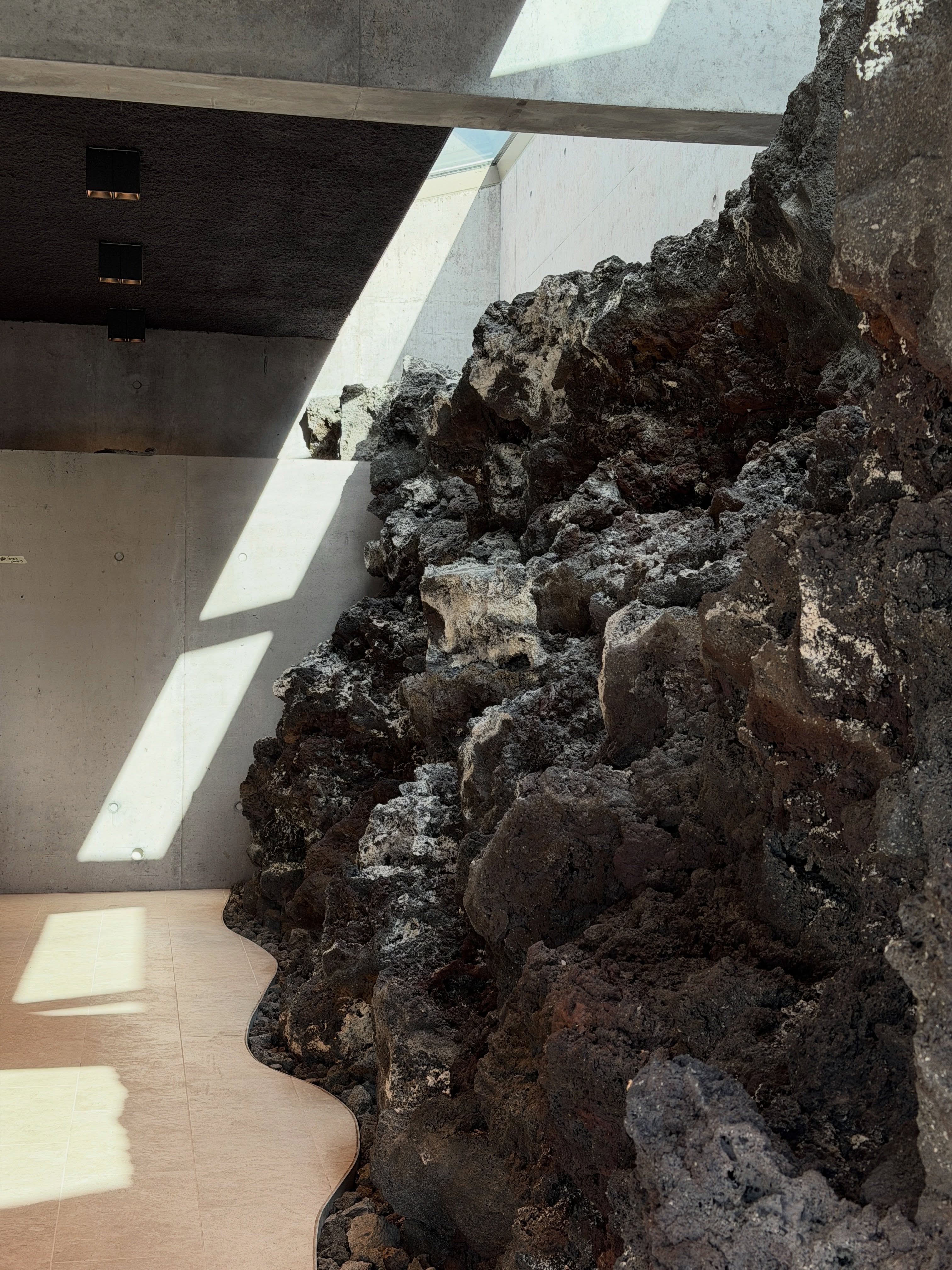 Preserved lava wall inside the new Earth Lagoon Mývatn building with daylight falling across the rock.