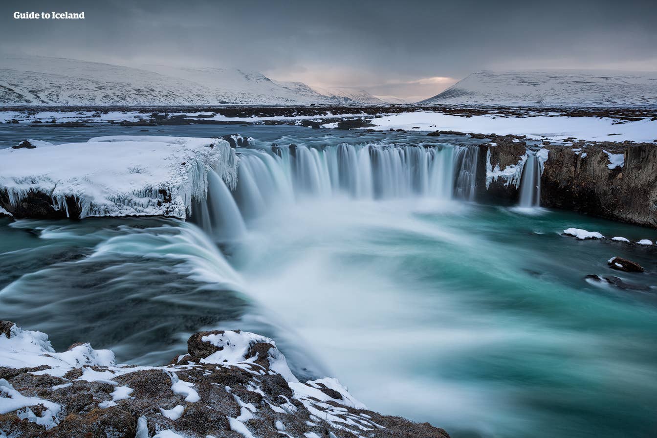 Goðafoss waterfall partly covered by snow and ice in North Iceland.