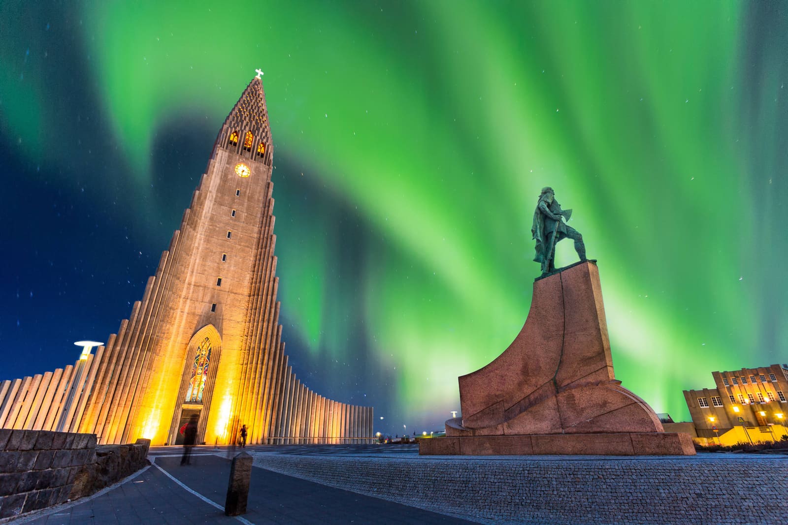 Hallgrímskirkja in Reykjavík under green northern lights.