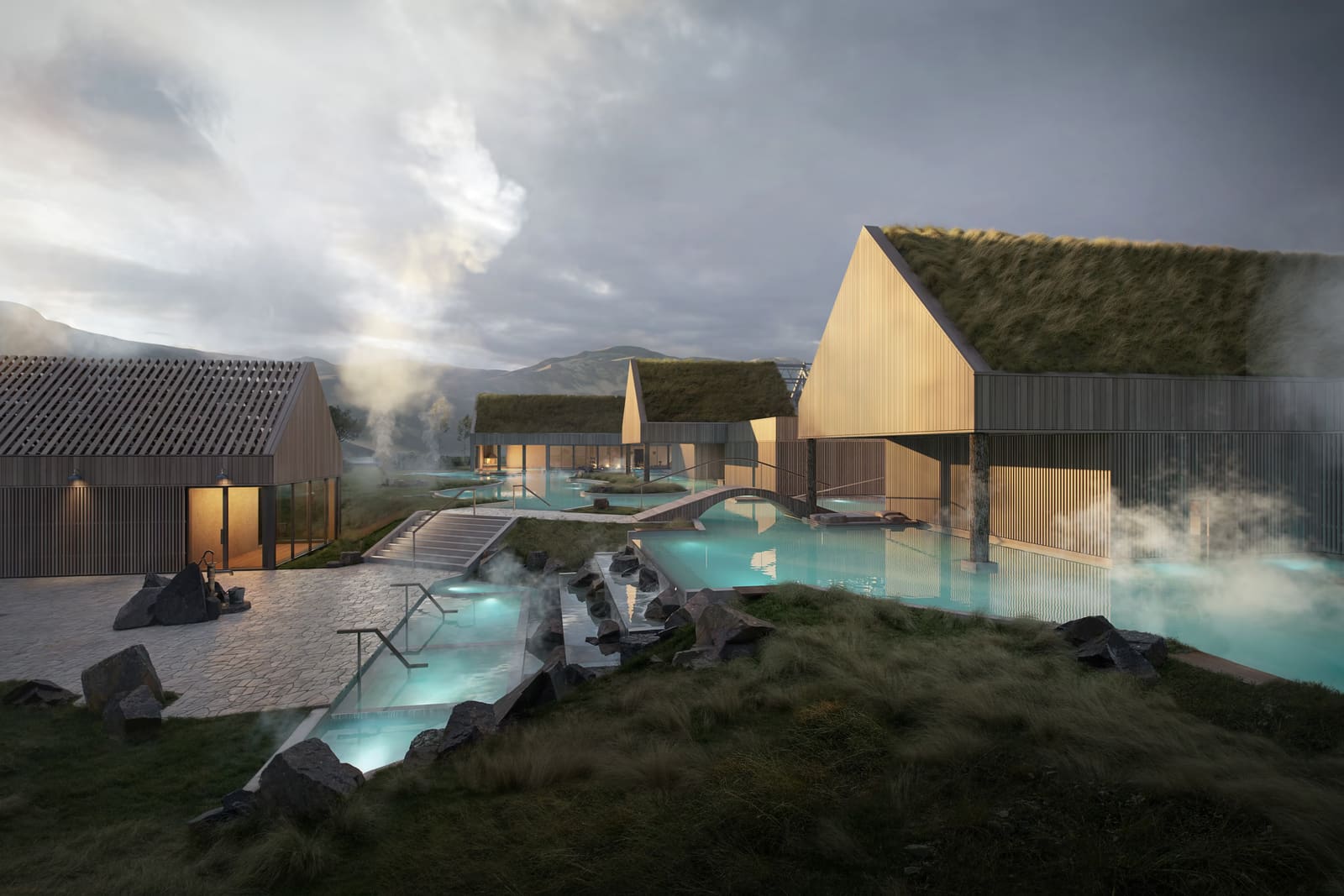 Promotional view of the Reykjaböð Hot Springs pools and turf-roofed bathhouse buildings in Reykjadalur valley.