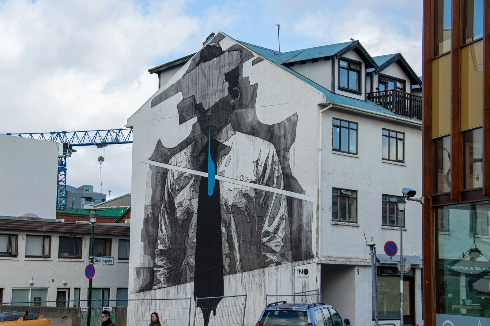 A large INO mural on a Reykjavik wall with a dramatic figure against a plain facade.