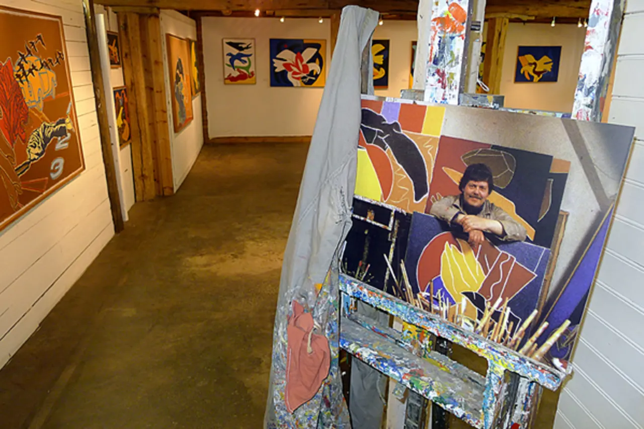 Easel and colorful paintings inside the Tryggvi Ólafsson collection at Neskaupstaður Museum House.
