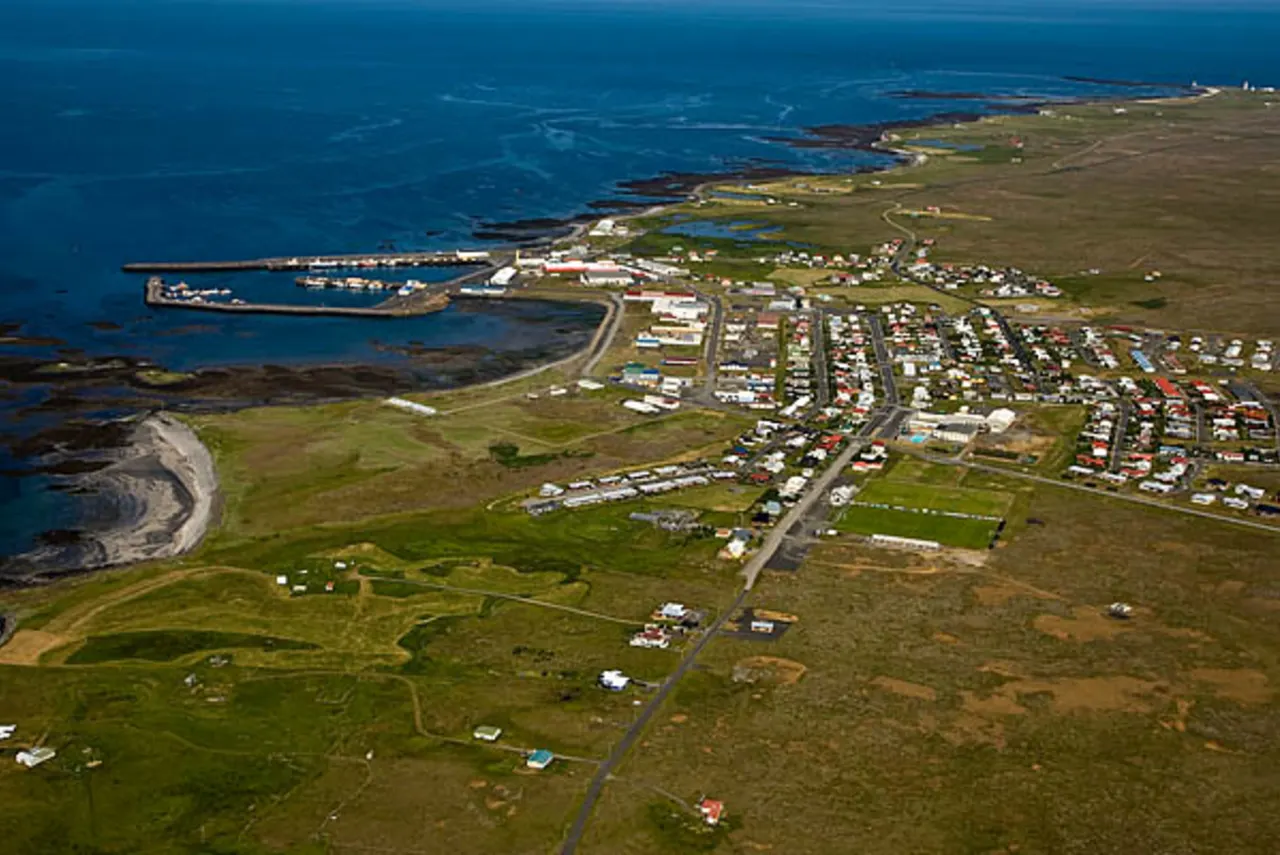Aerial view of Sandgerði with its harbor, low coastline, and town streets on the Reykjanes Peninsula.