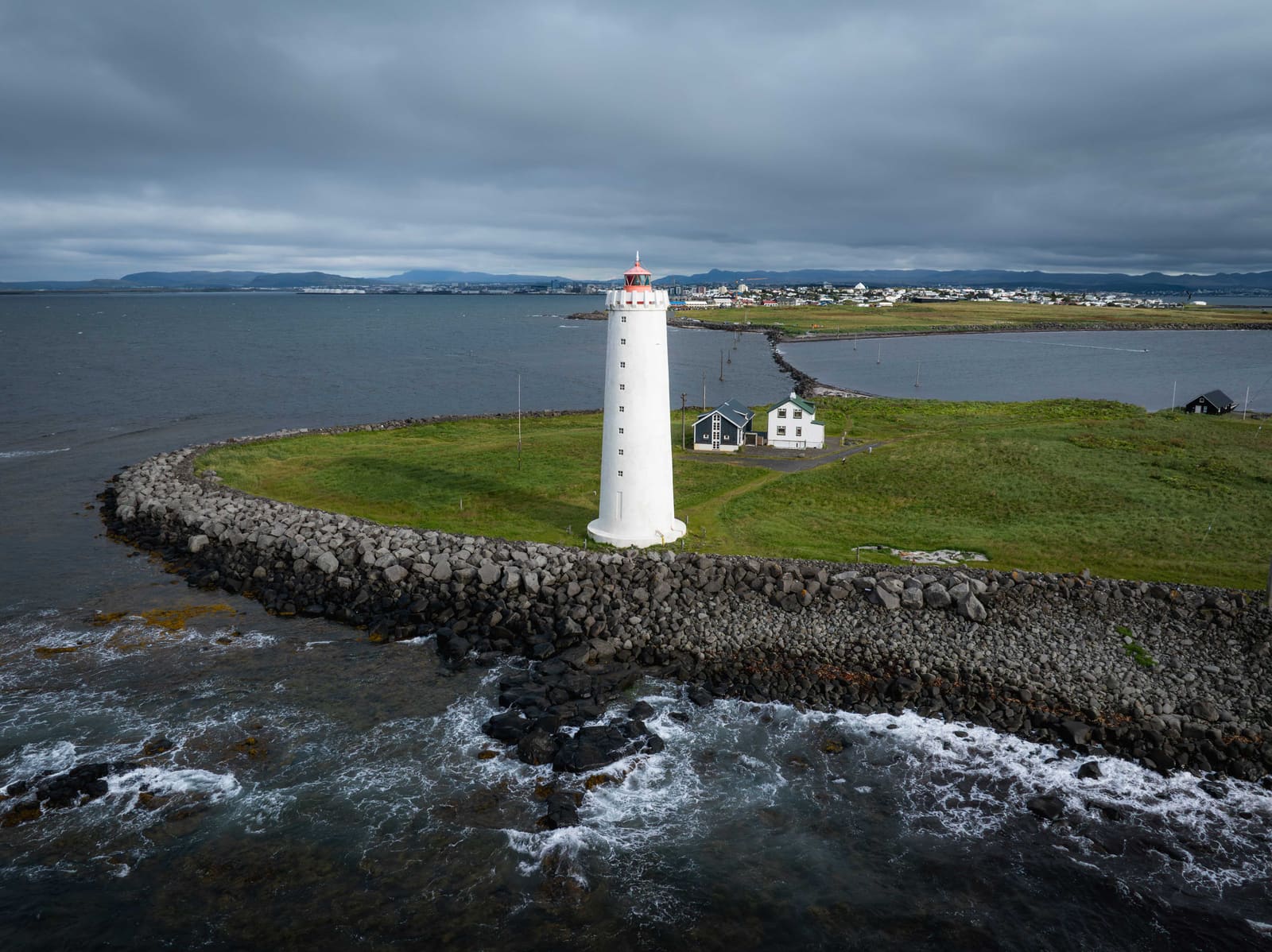 Grótta lighthouse surrounded by the rocky Seltjarnarnes shoreline