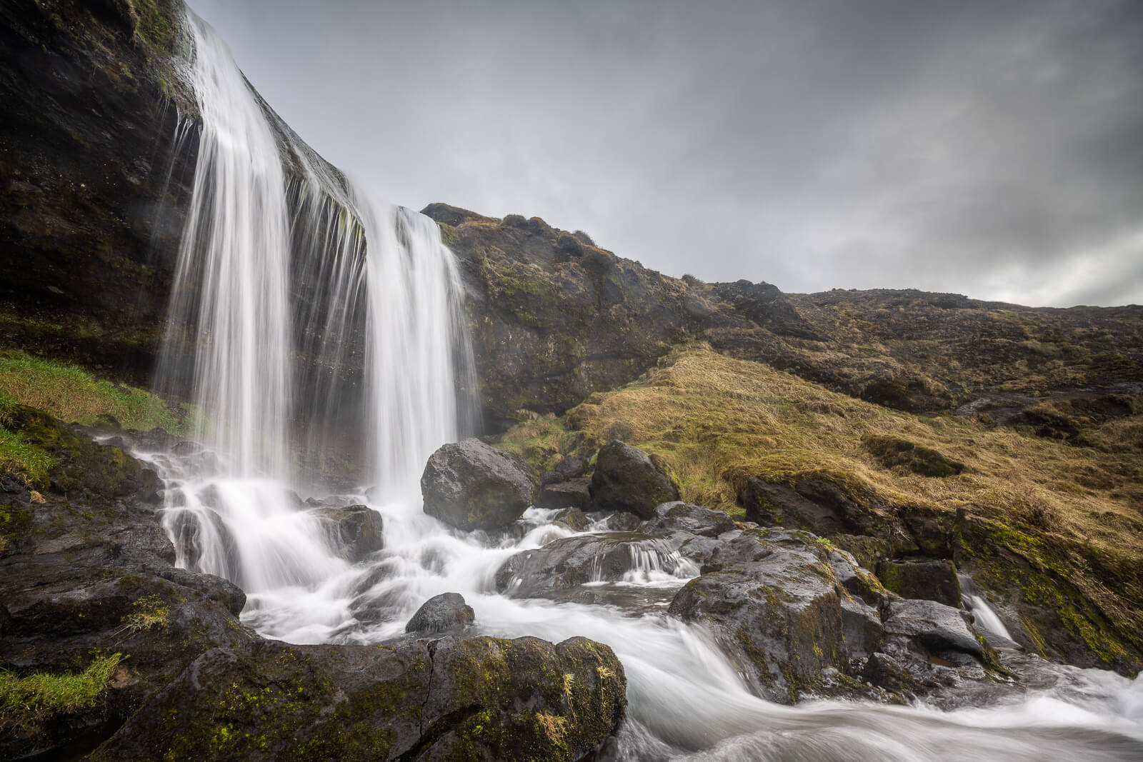 Close view of Selvallafoss spray and dark rocks below the main cascade.