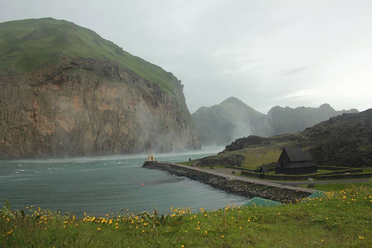 Skansinn Fort area beside Heimaey harbor with historic stonework and island backdrop.