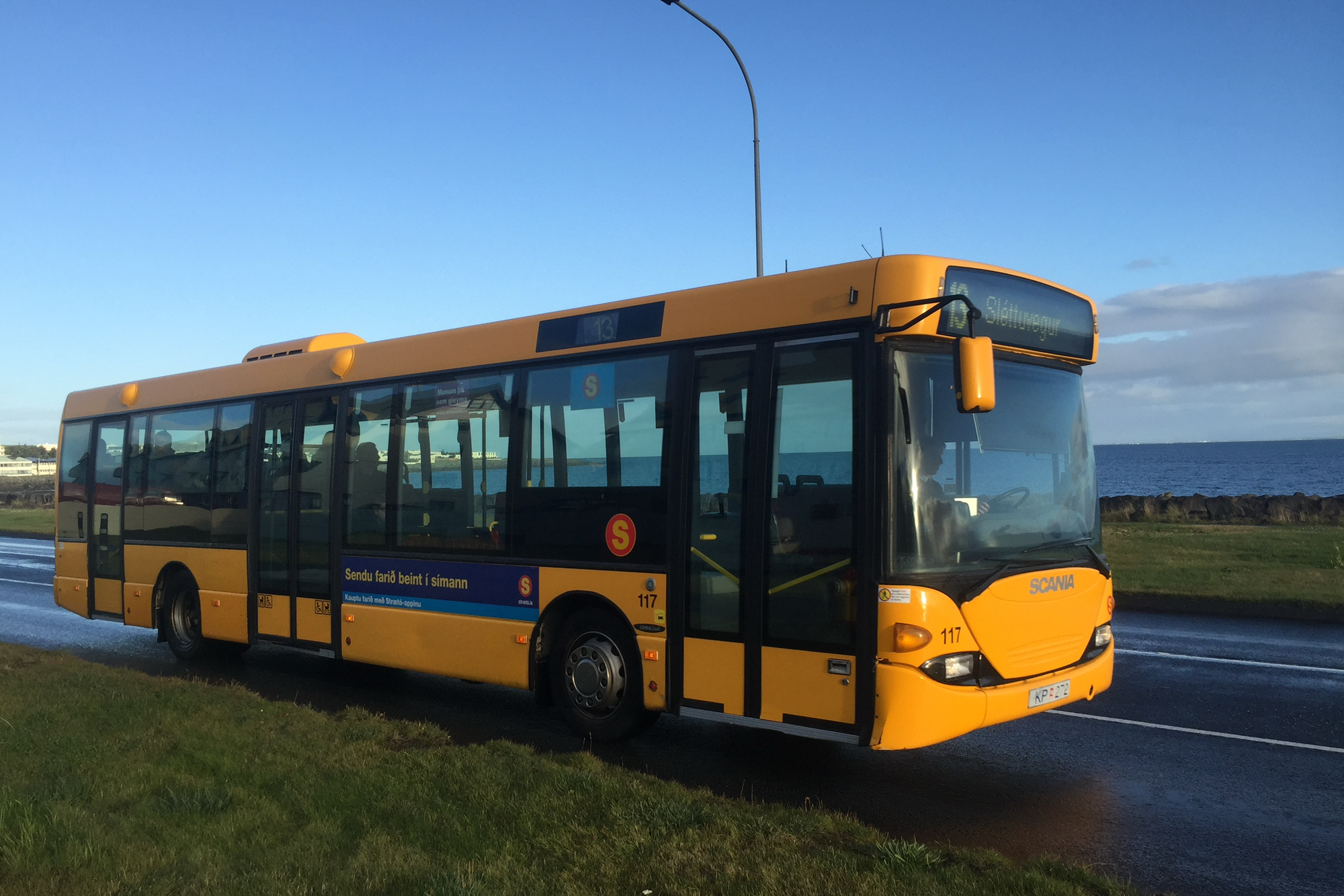Yellow Strætó bus on a road near the capital area.