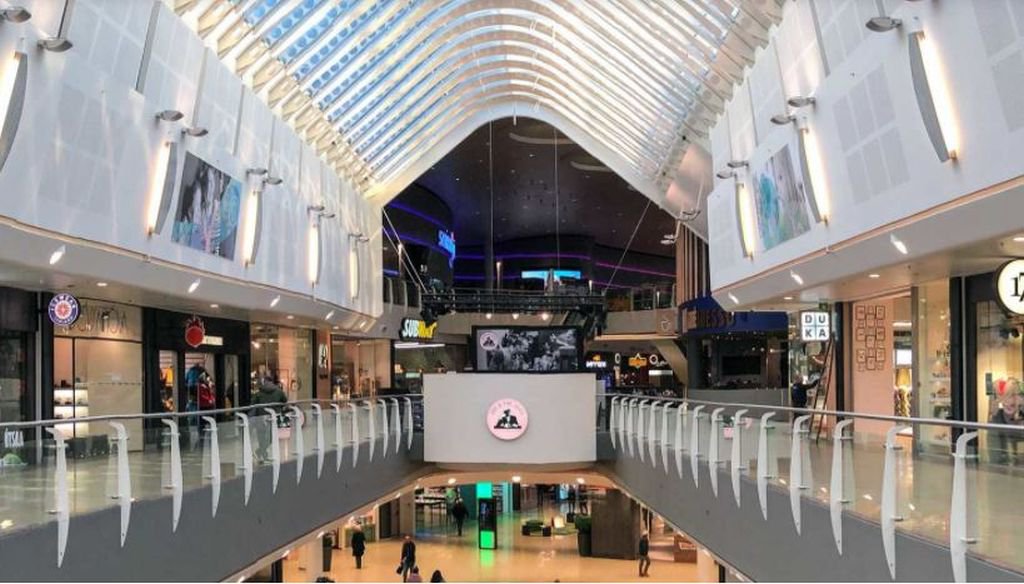 Interior corridor and upper-level storefronts inside Smáralind Shopping Mall.